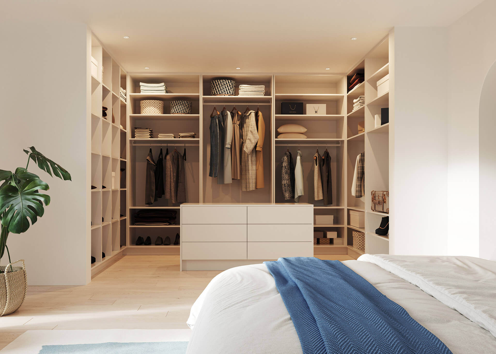 Dressing ouvert sur mesure avec un îlot central blanc, vu depuis le lit dans la chambre