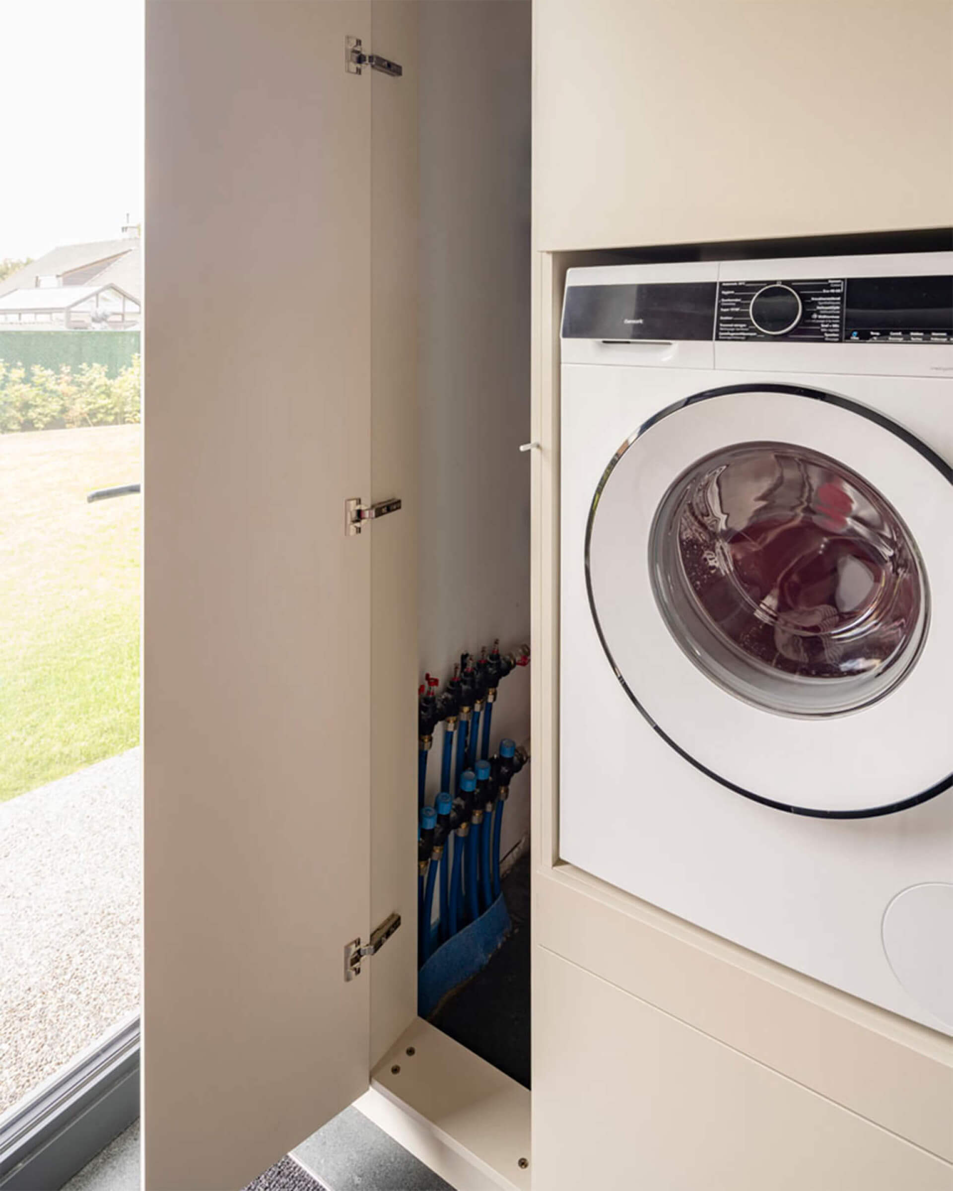 collecteurs dissimulés dans une armoire technologique combinée à une armoire pour lave-linge 