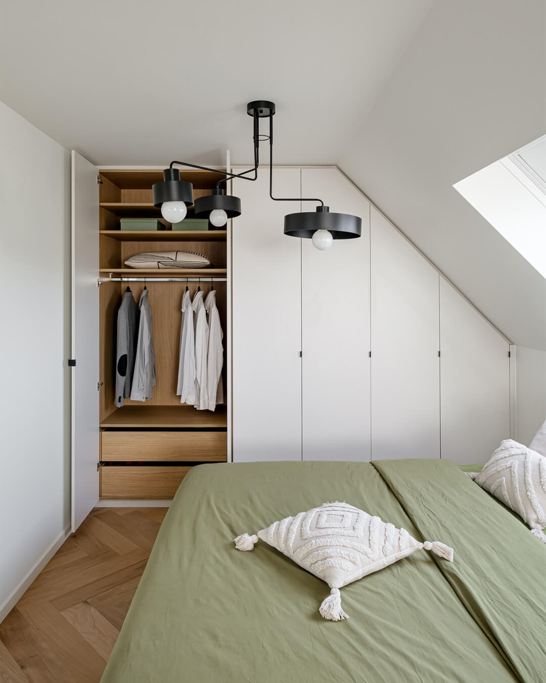 Placard avec un côté en pente en blanc cassé et une texture en bois à l'intérieur.