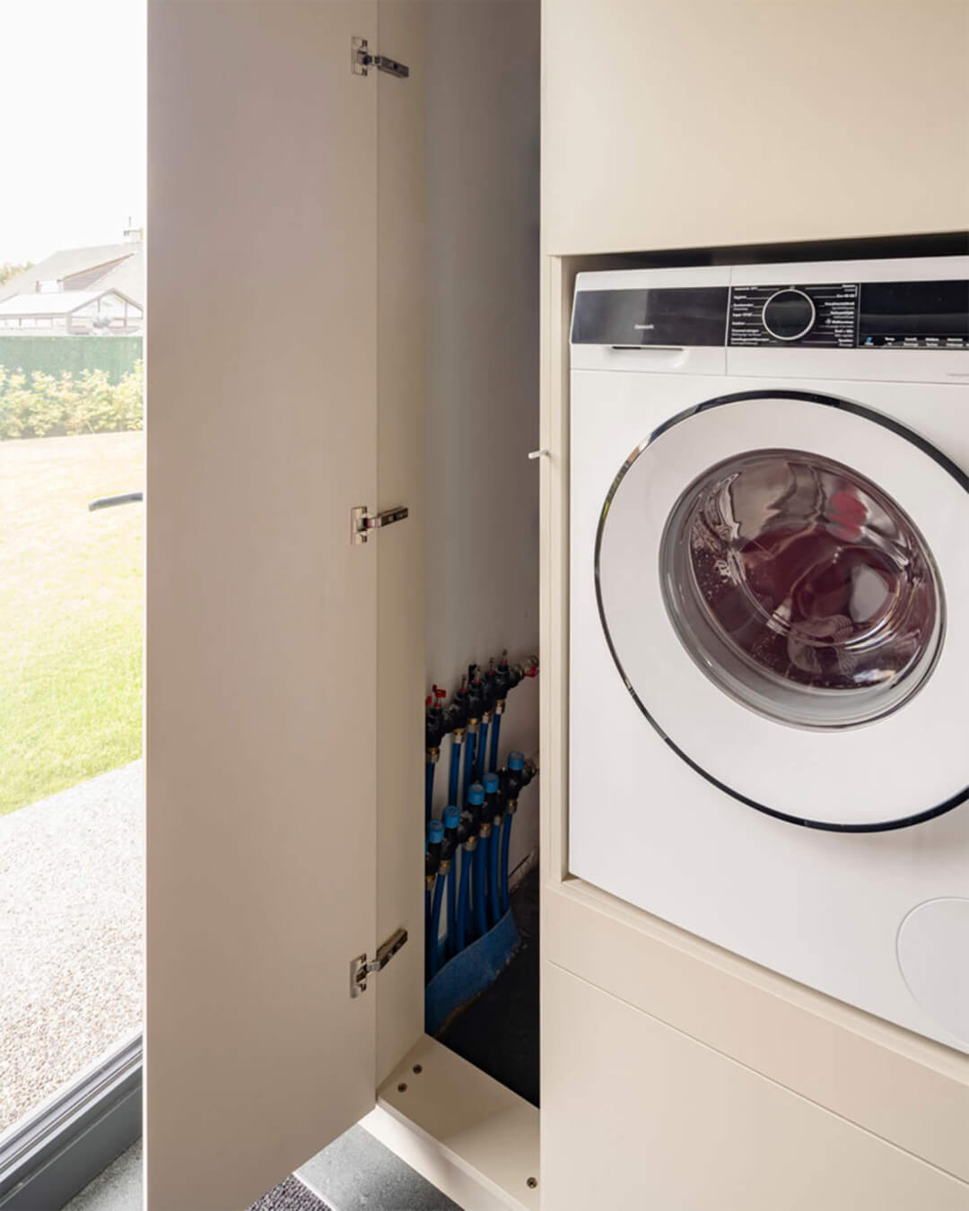 Combinaison murale d'armoires hautes et basses sur mesure avec espace pour une machine à laver intégrée et armoire technique en couleur gris chaud Turtle Grey