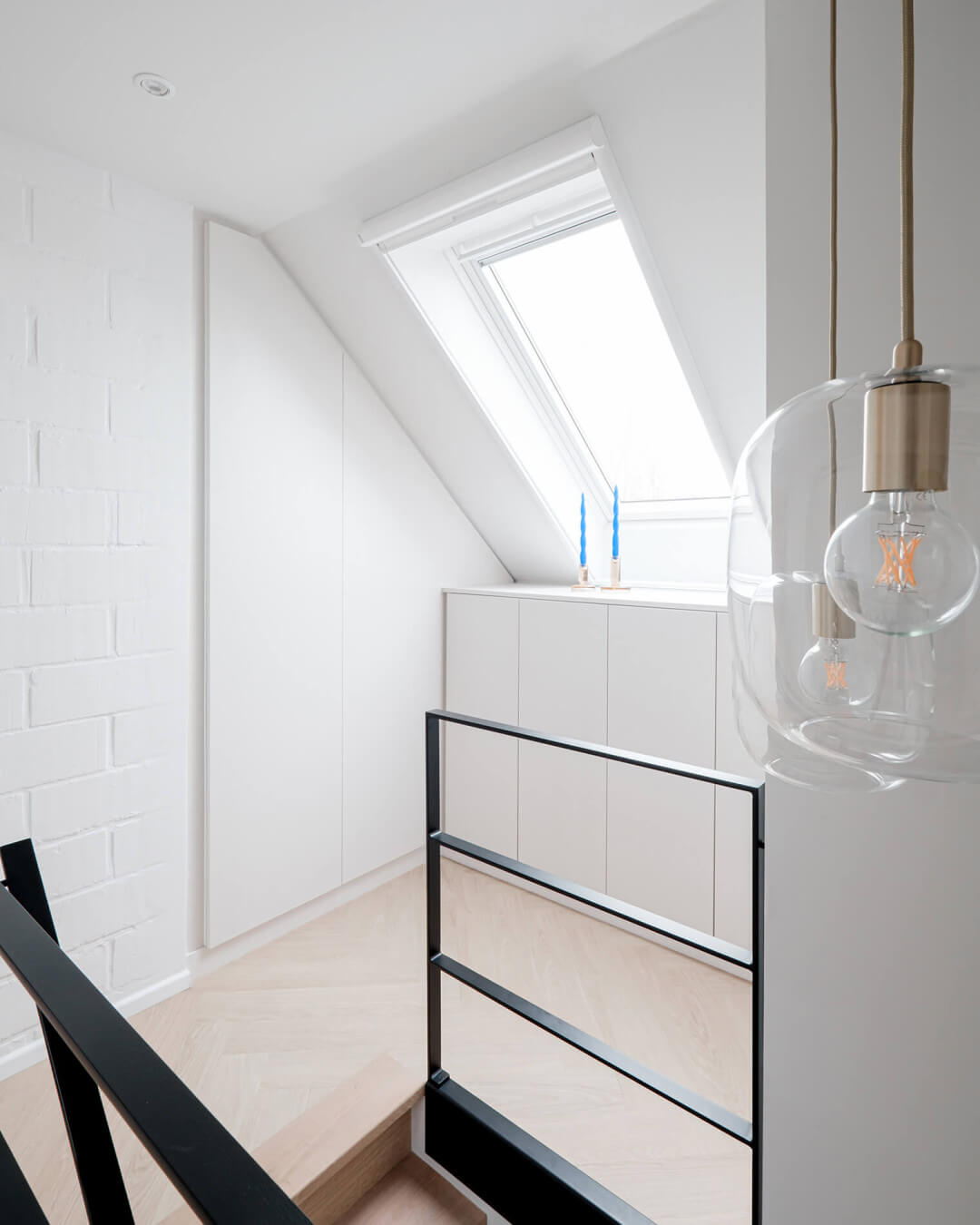 Armoire technique blanche sur mesure sous le toit en pente dans le palier