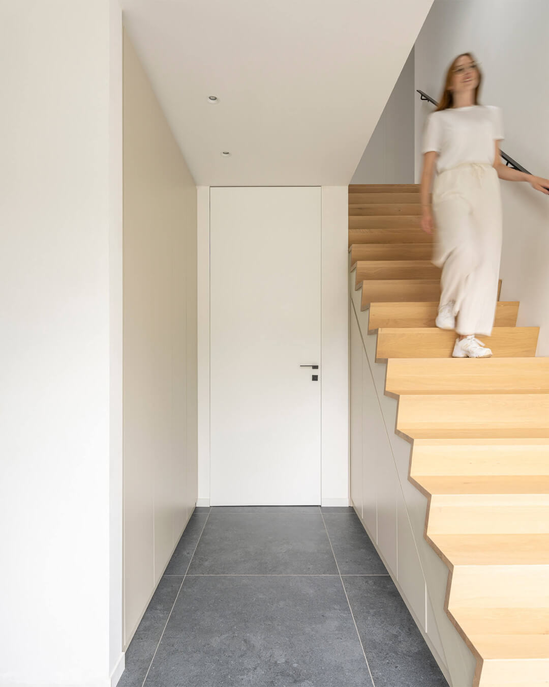 Armoire de vestiaire sur mesure en couleur Turtle Grey, à côté d'un escalier en chêne