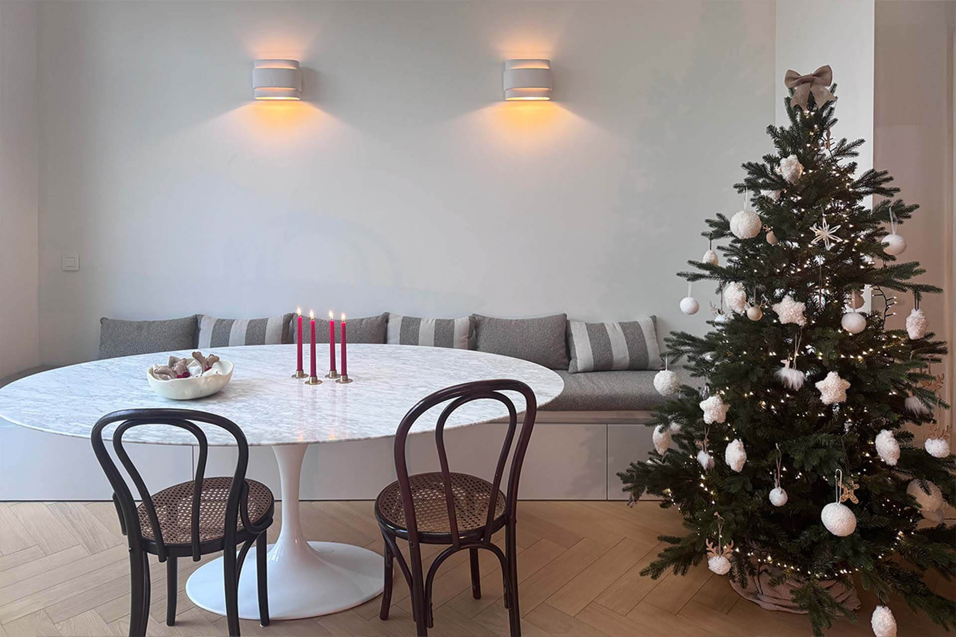 Banquette de rangement sur mesure en coquillage avec poignée, sapin de Noël et bougies sur la table
