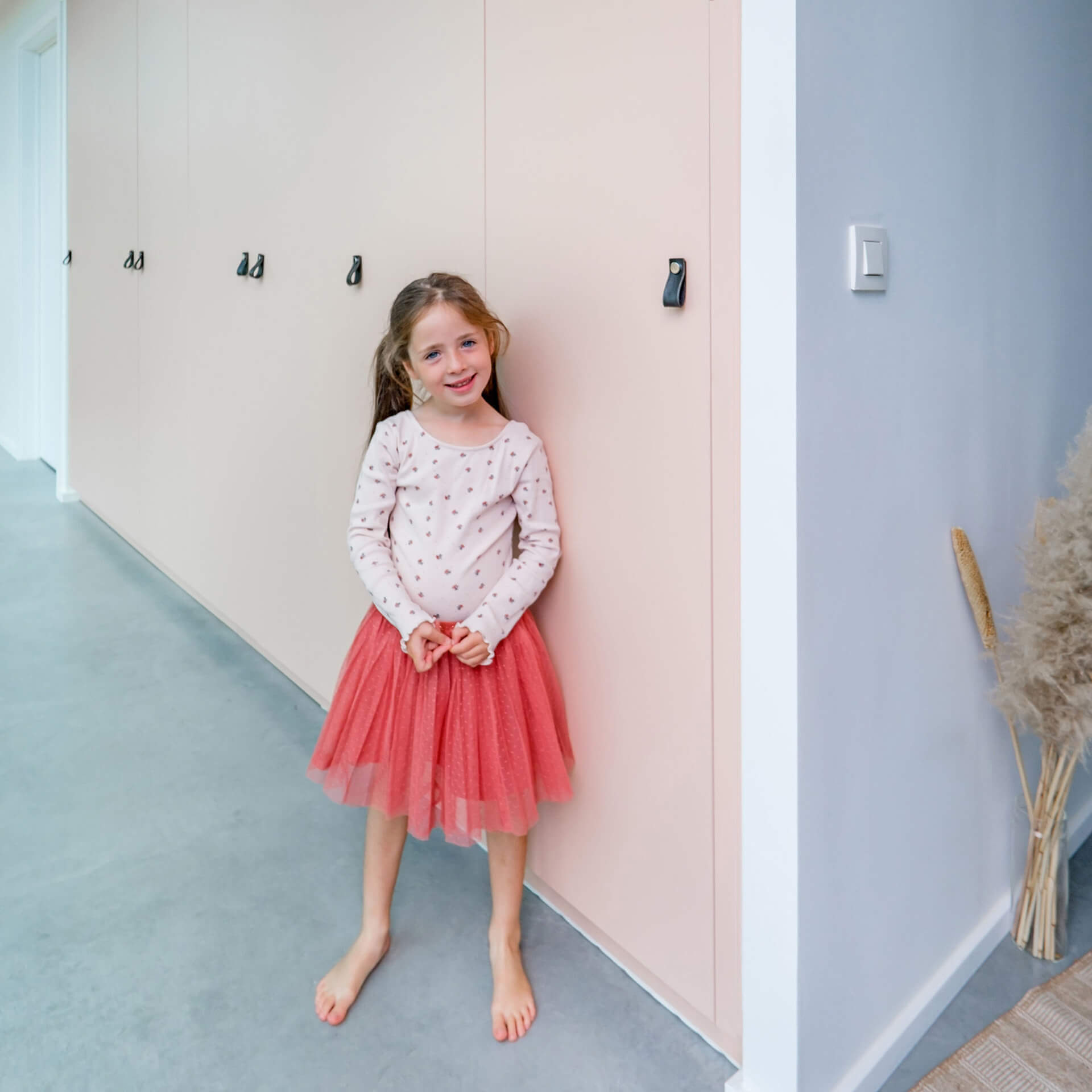 Une jeune fille devant une armoire encastrée rose de custoro.