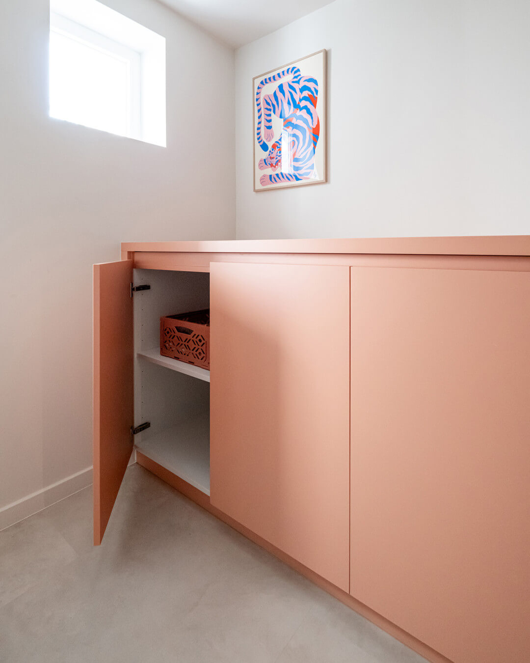 Armoire de rangement sur mesure rose dans la buanderie de la maison Sundae