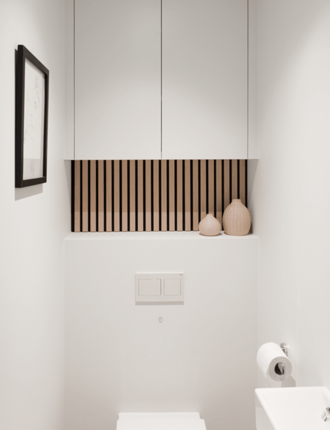 Panneaux muraux acoustiques en chêne ivoire associés à un meuble WC blanc.