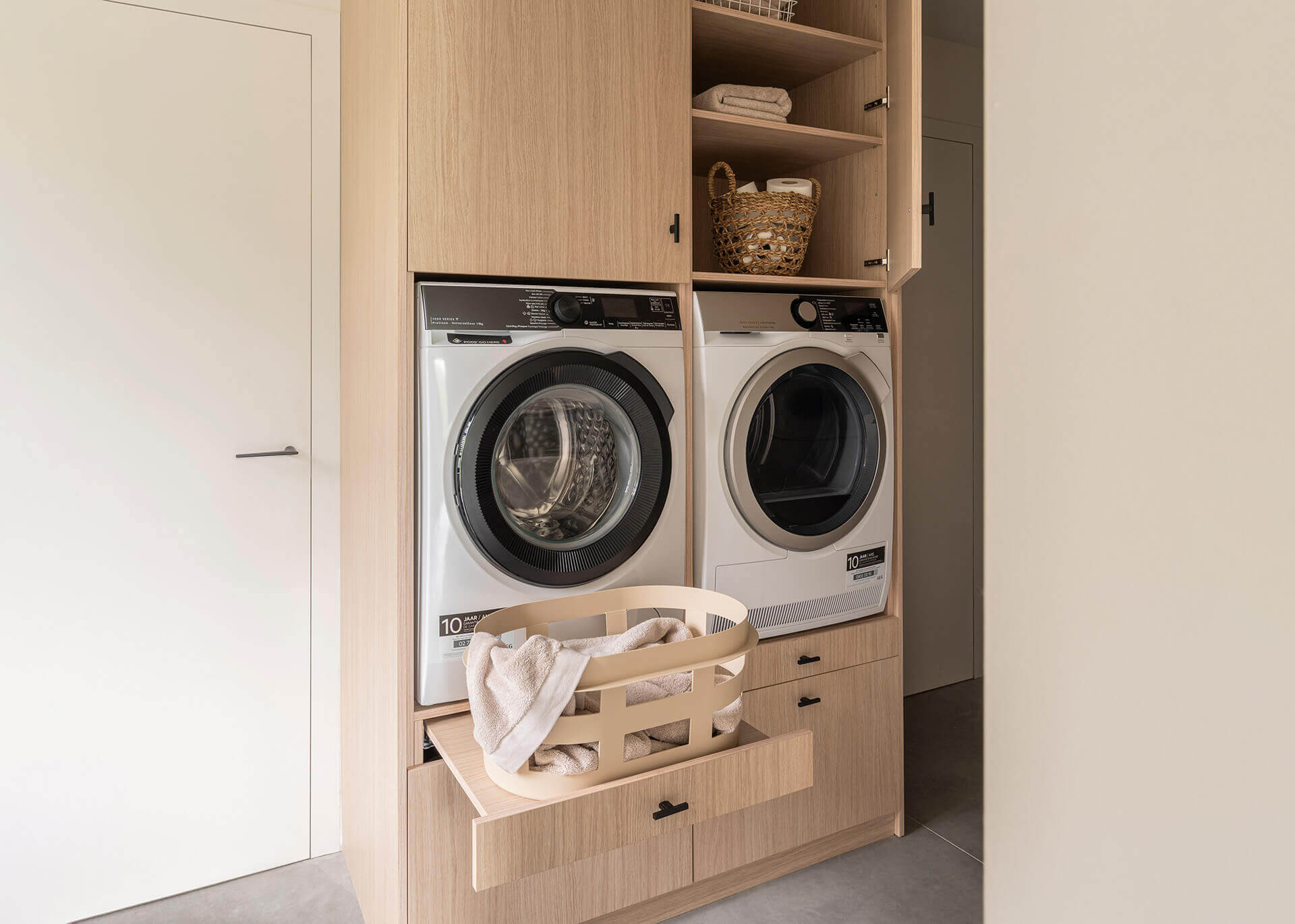 Une armoire haute avec lave-linge et sèche-linge en chêne Atlas, panier à linge prêt à l'emploi