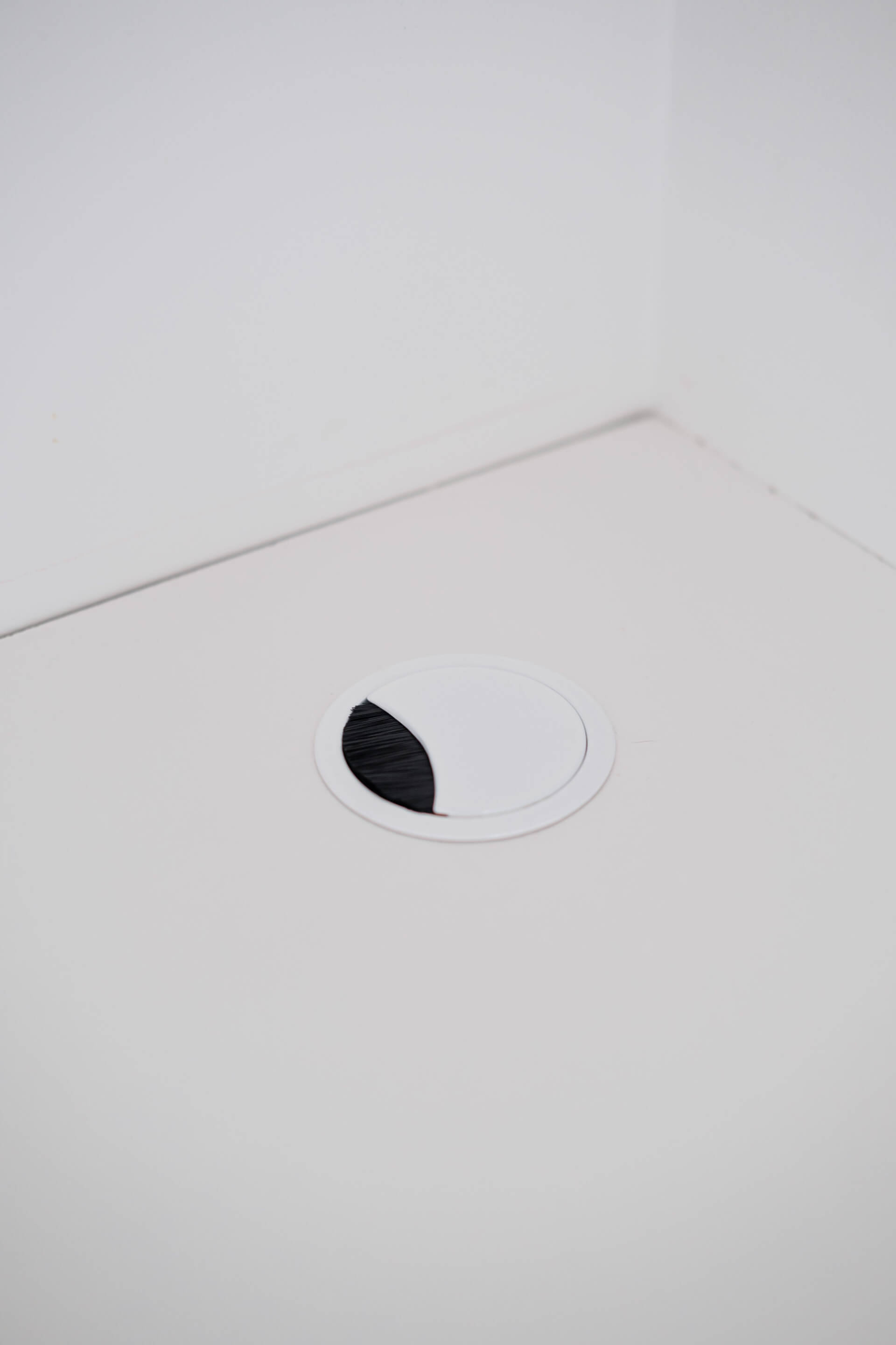 Passe-câble blanc Custoro dans un bureau avec rangements sur mesure