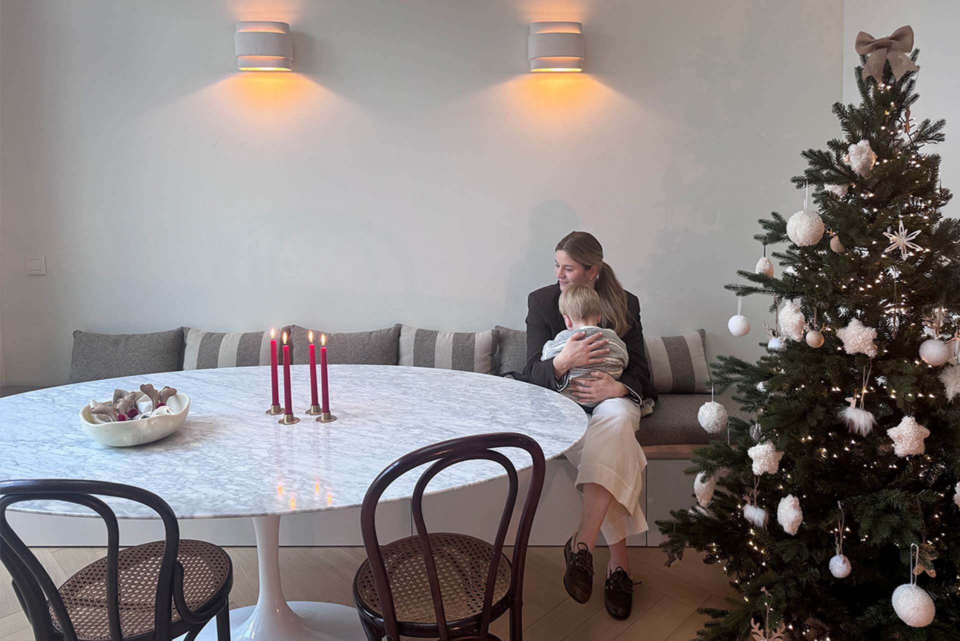 Mère et fils assis sur un banc Seashell avec barre d'appui dans une salle à manger décorée pour Noël