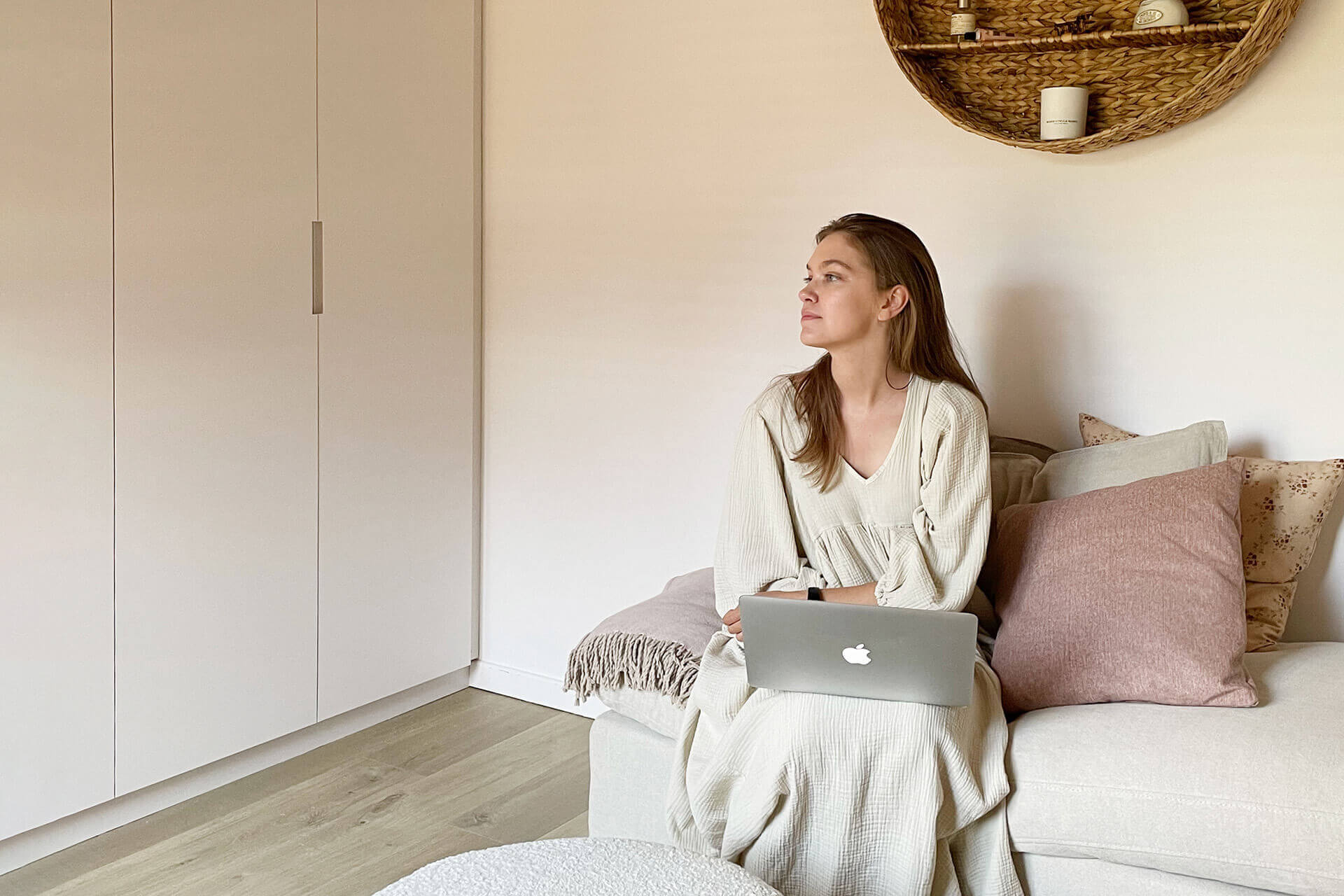 Romy est assise dans le canapé près de son armoire sur mesure de custoro.
