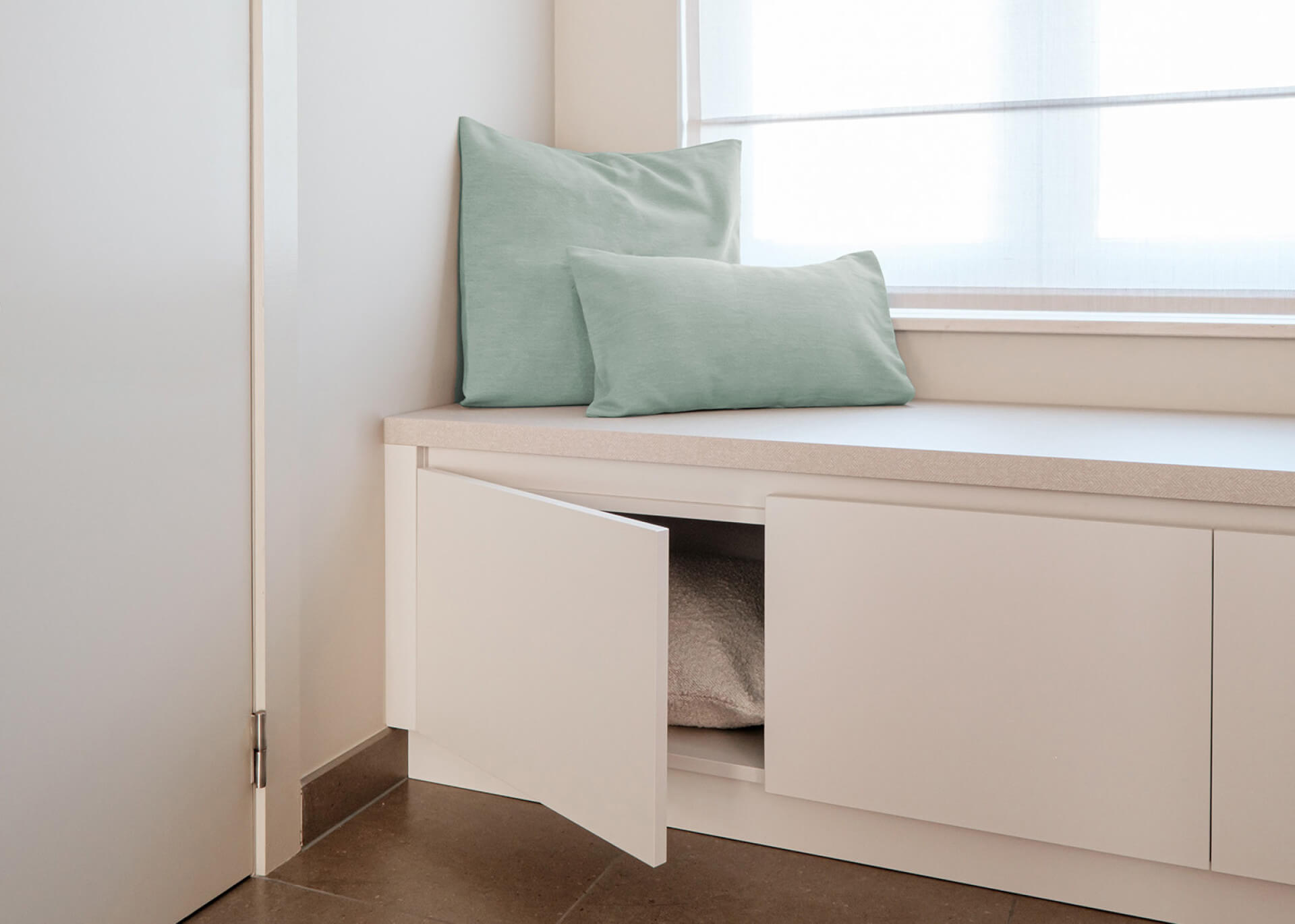Banc de rangement sur mesure dans une douce teinte beige dans le salon