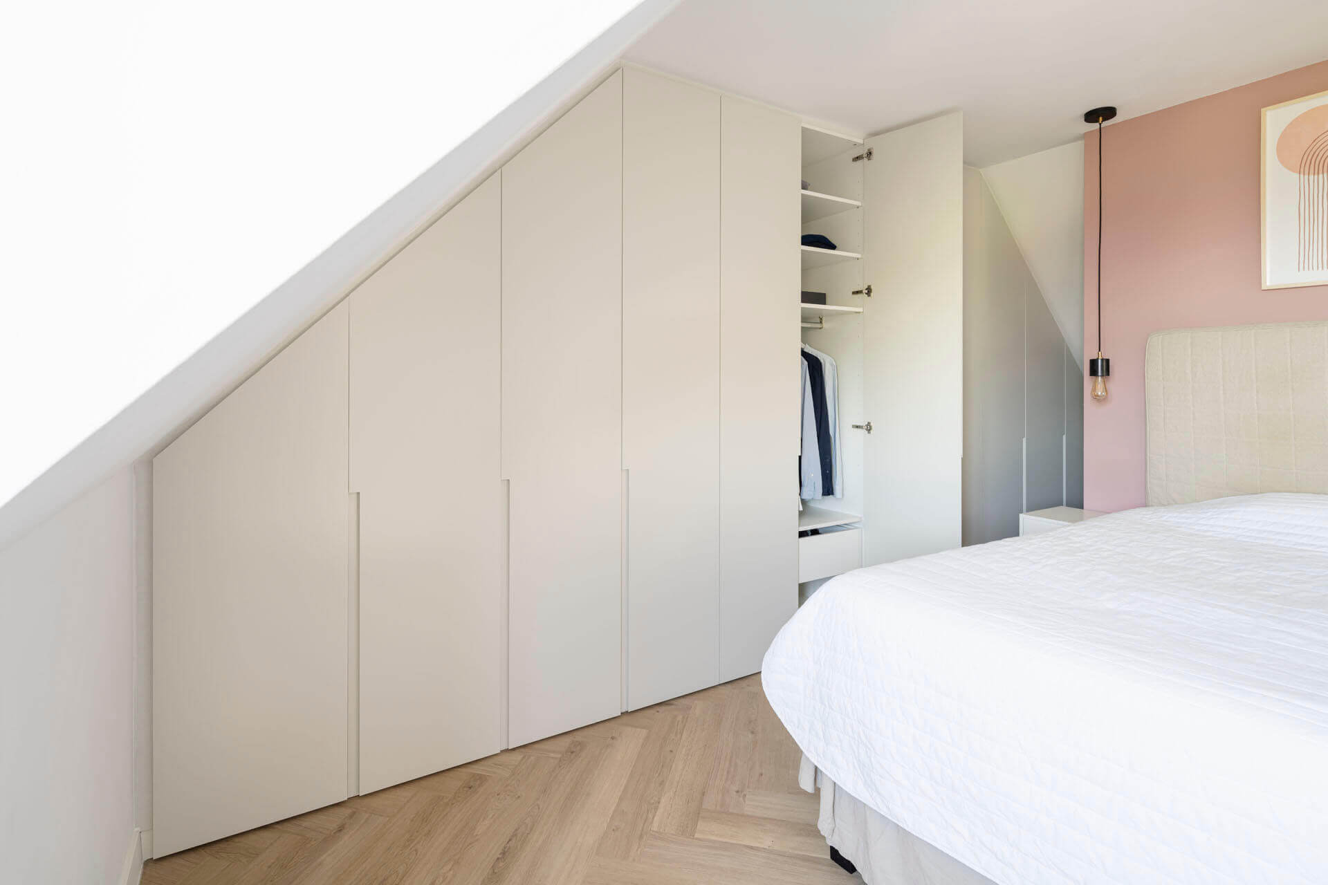 Armoire dressing blanche sous un toit en pente