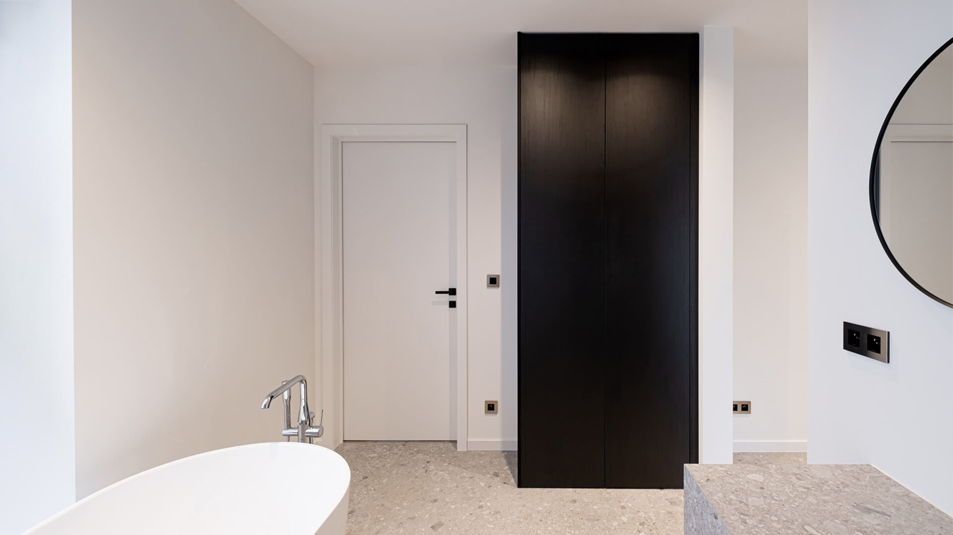 Meuble de rangement noir sur mesure dans une salle de bains.