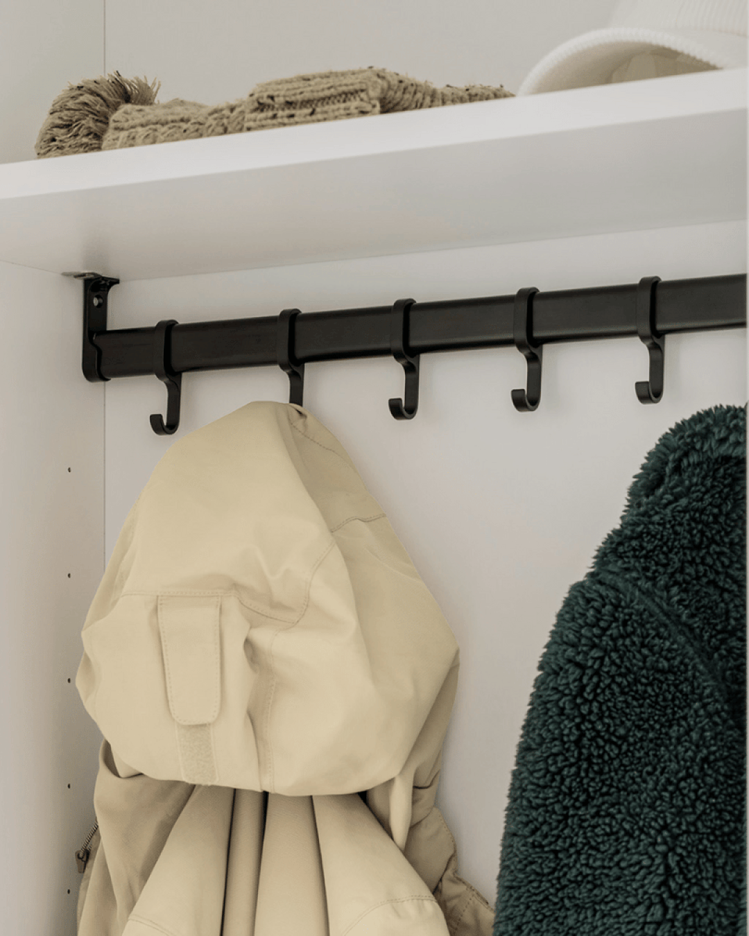 Les vestes sont suspendues à un crochet pour cintres dans un vestiaire.