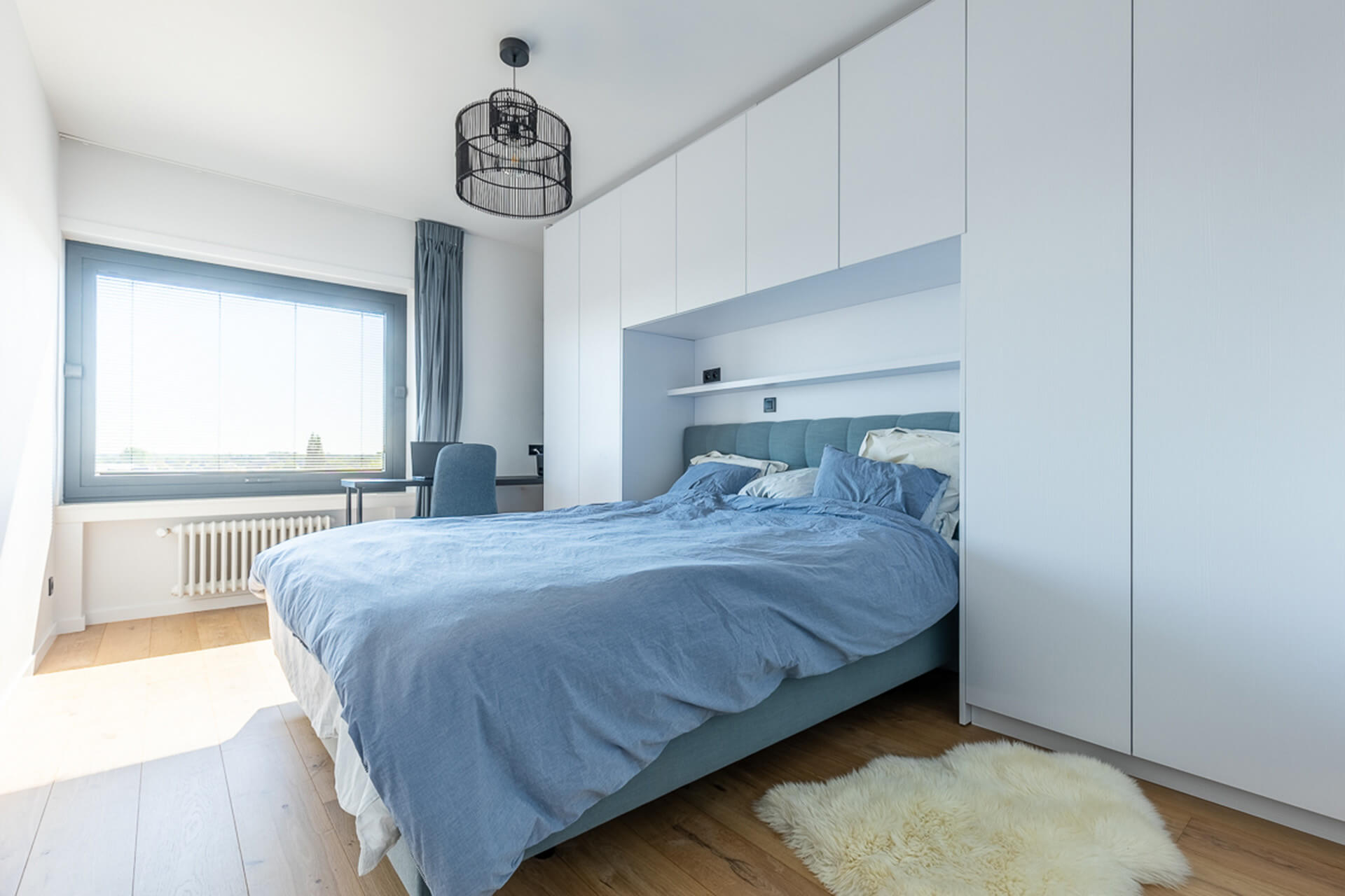 Armoire blanche sur mesure au-dessus du lit dans la chambre à coucher