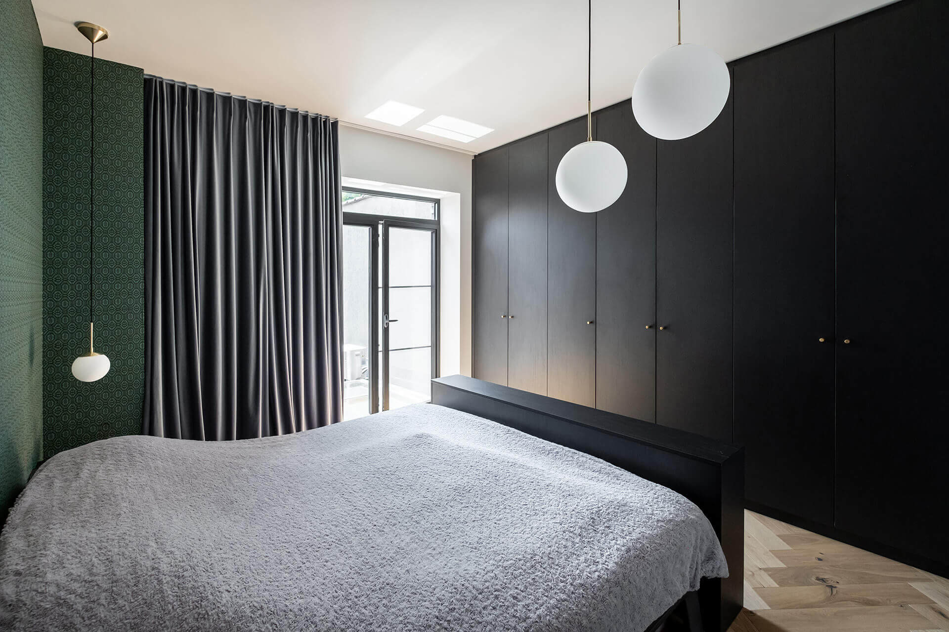 Armoire noire encastrée sur mesure avec poignées monumentales dorées dans la chambre à coucher