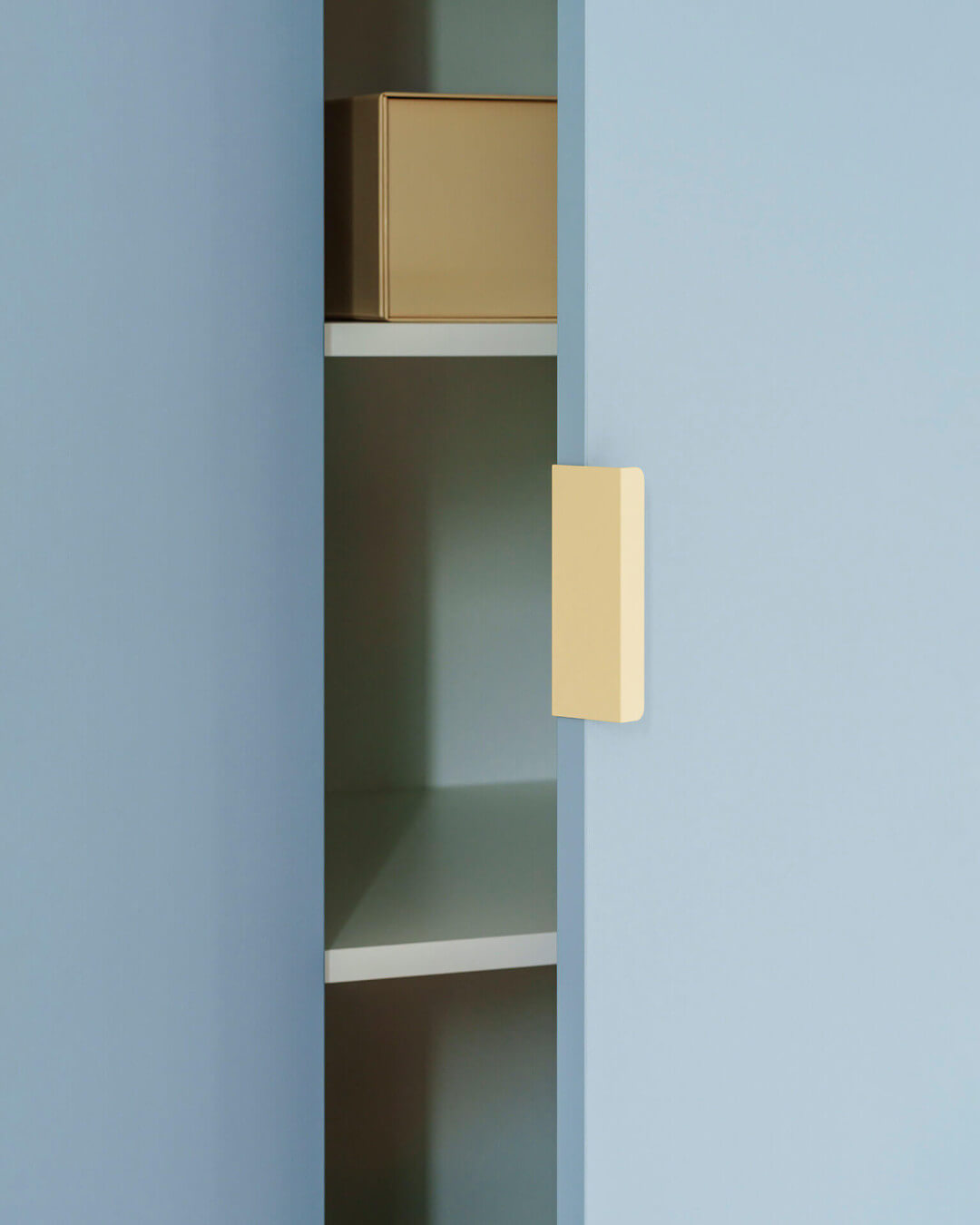 Poignée de couleur crème dans une armoire sur mesure de couleur Silver Blue de Custoro.