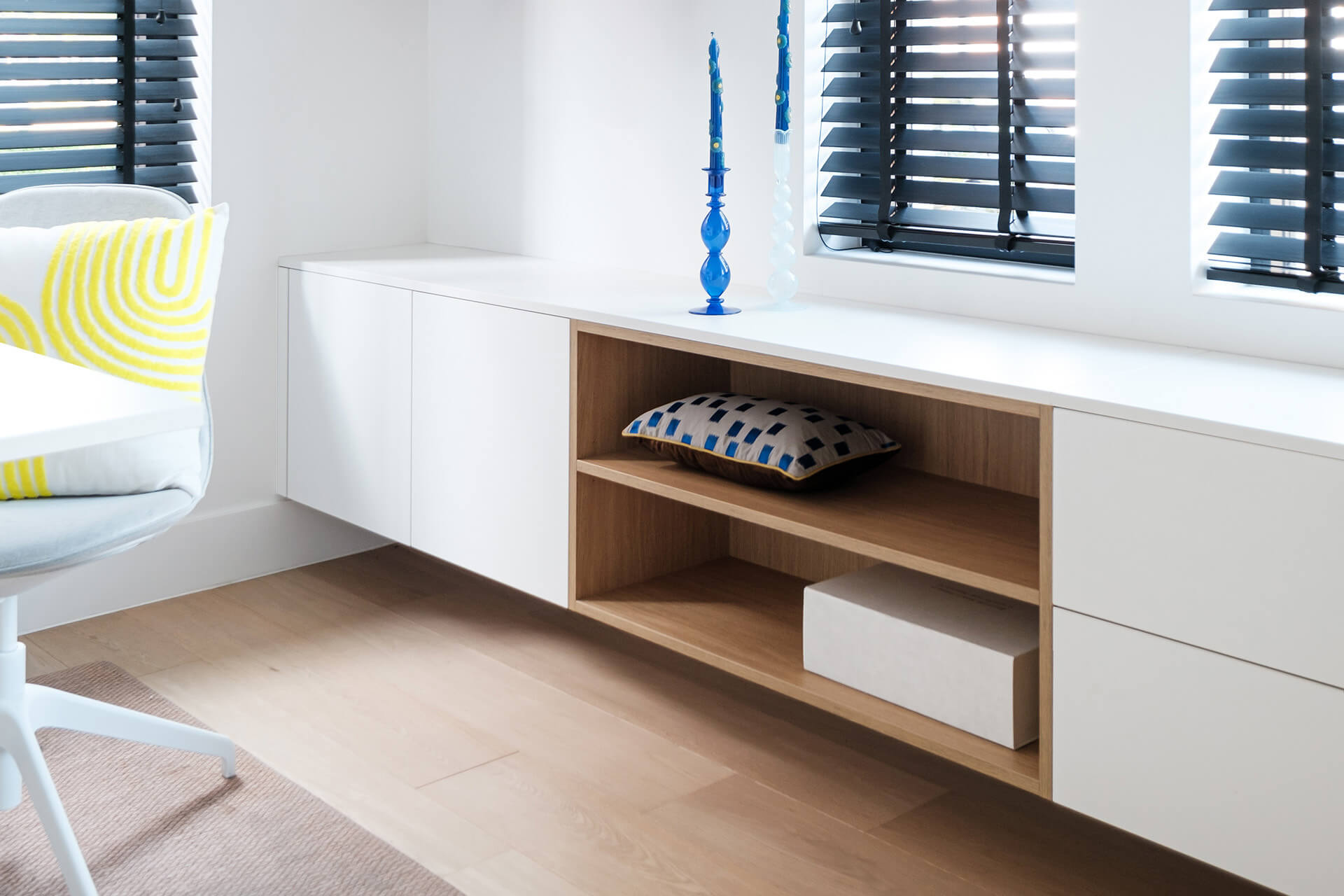 Commode suspendue blanche avec niche ouverte dans une structure en bois, dans un espace de bureau