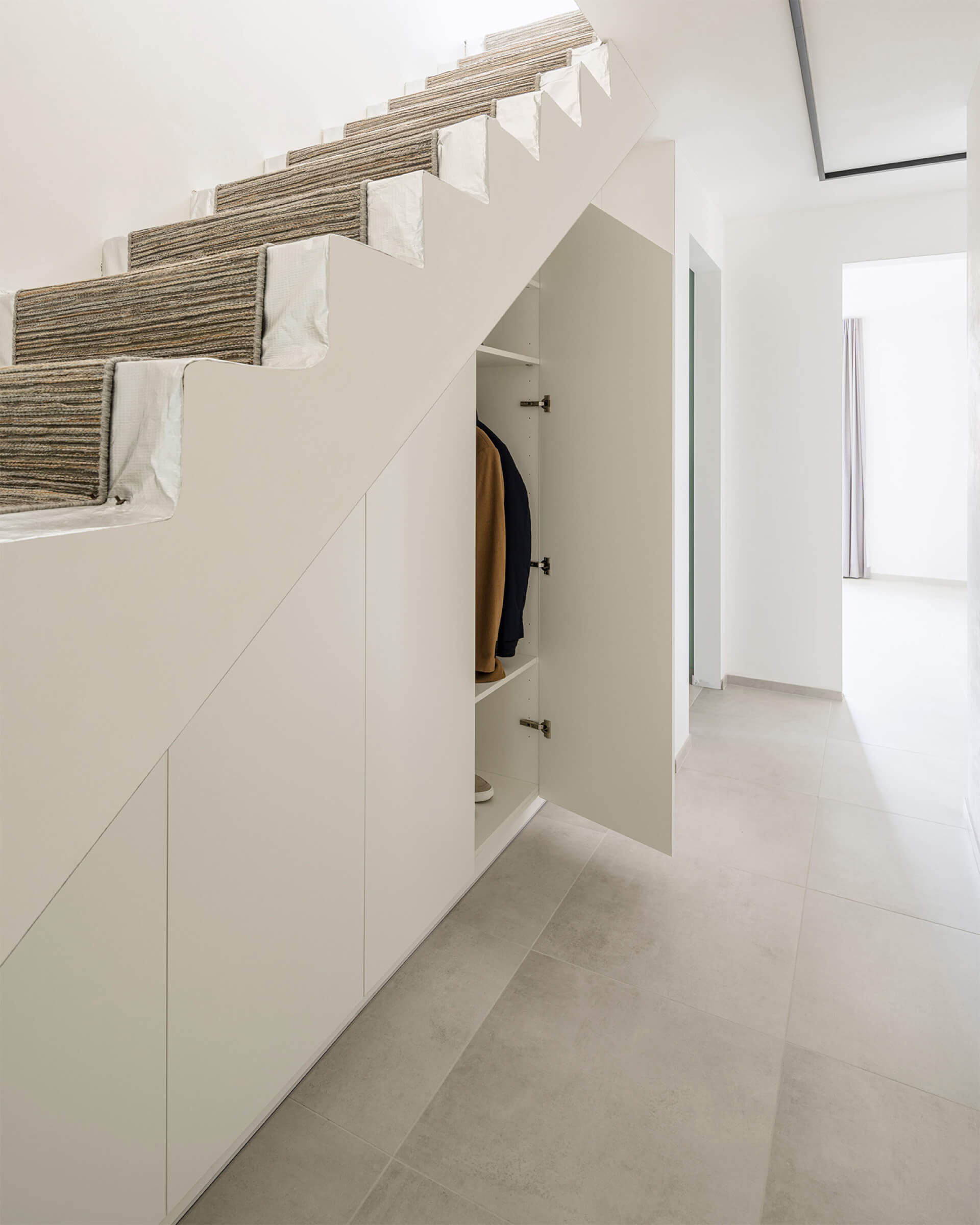 Dressing dans une armoire sur mesure sous l'escalier