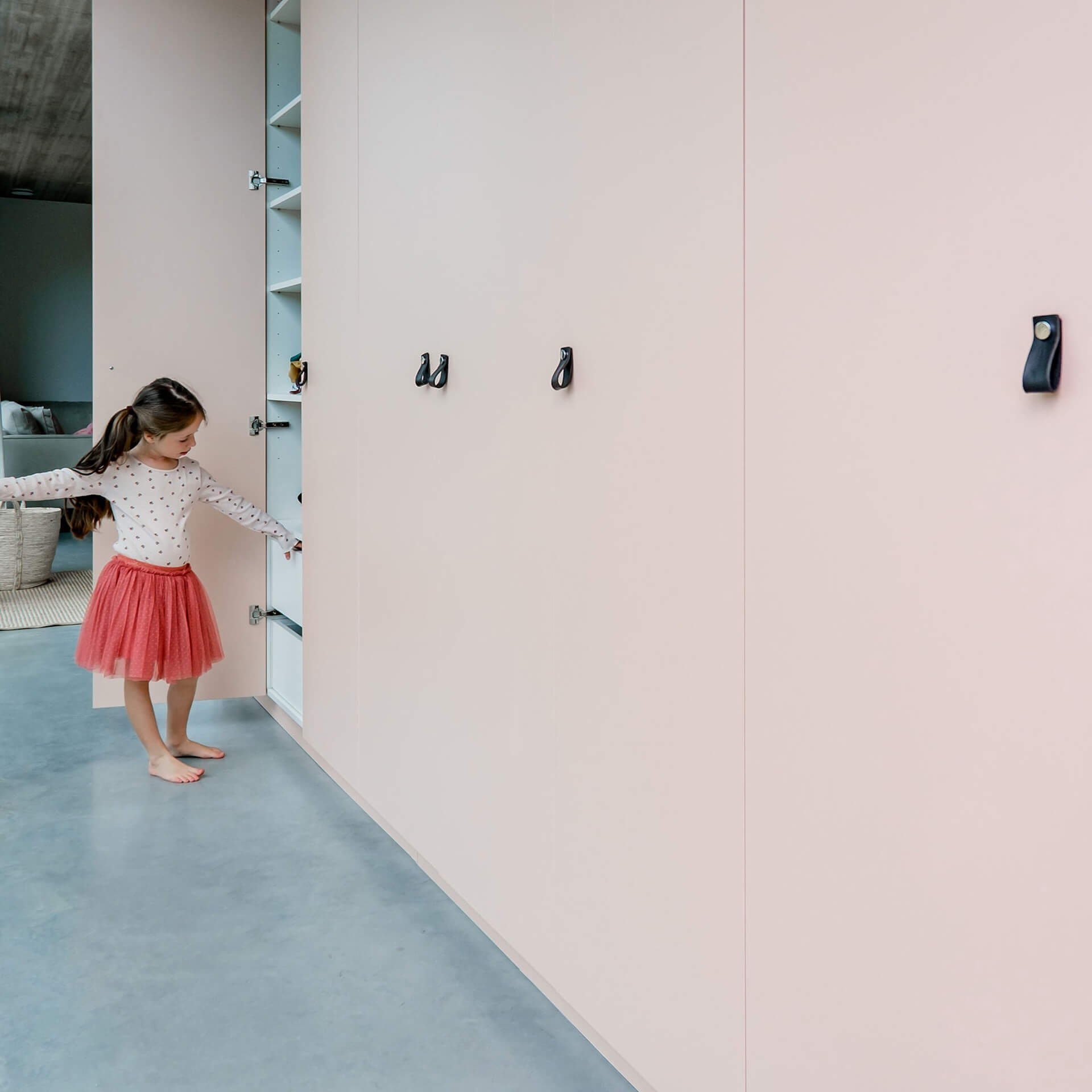 Une fille ouvre une armoire encastrée en couleur Tanned Peach de bespokekastenonline