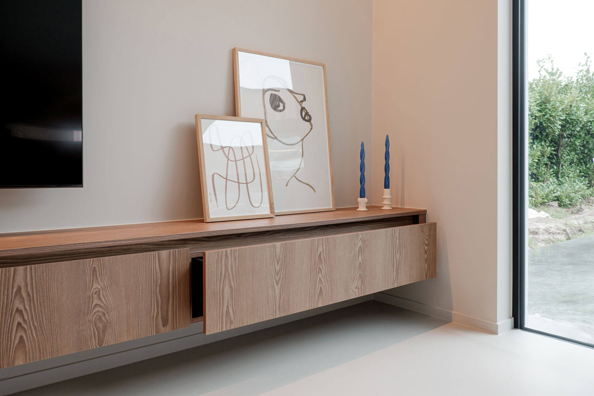 Un meuble TV long en Sunlit Brown avec deux cadres photo et des bougies