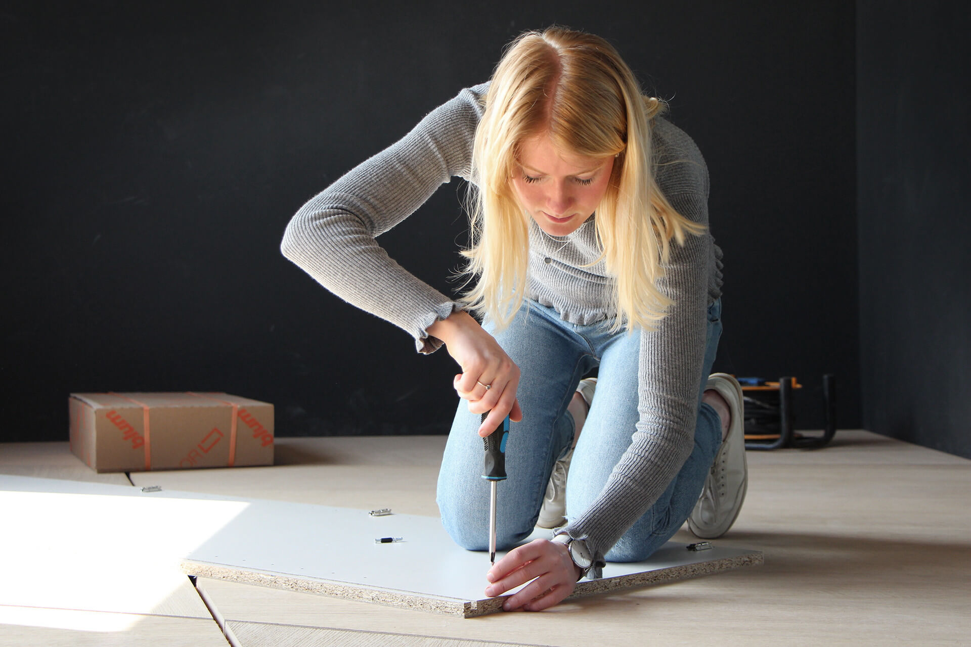 Une personne installe une armoire dans un espace vide.