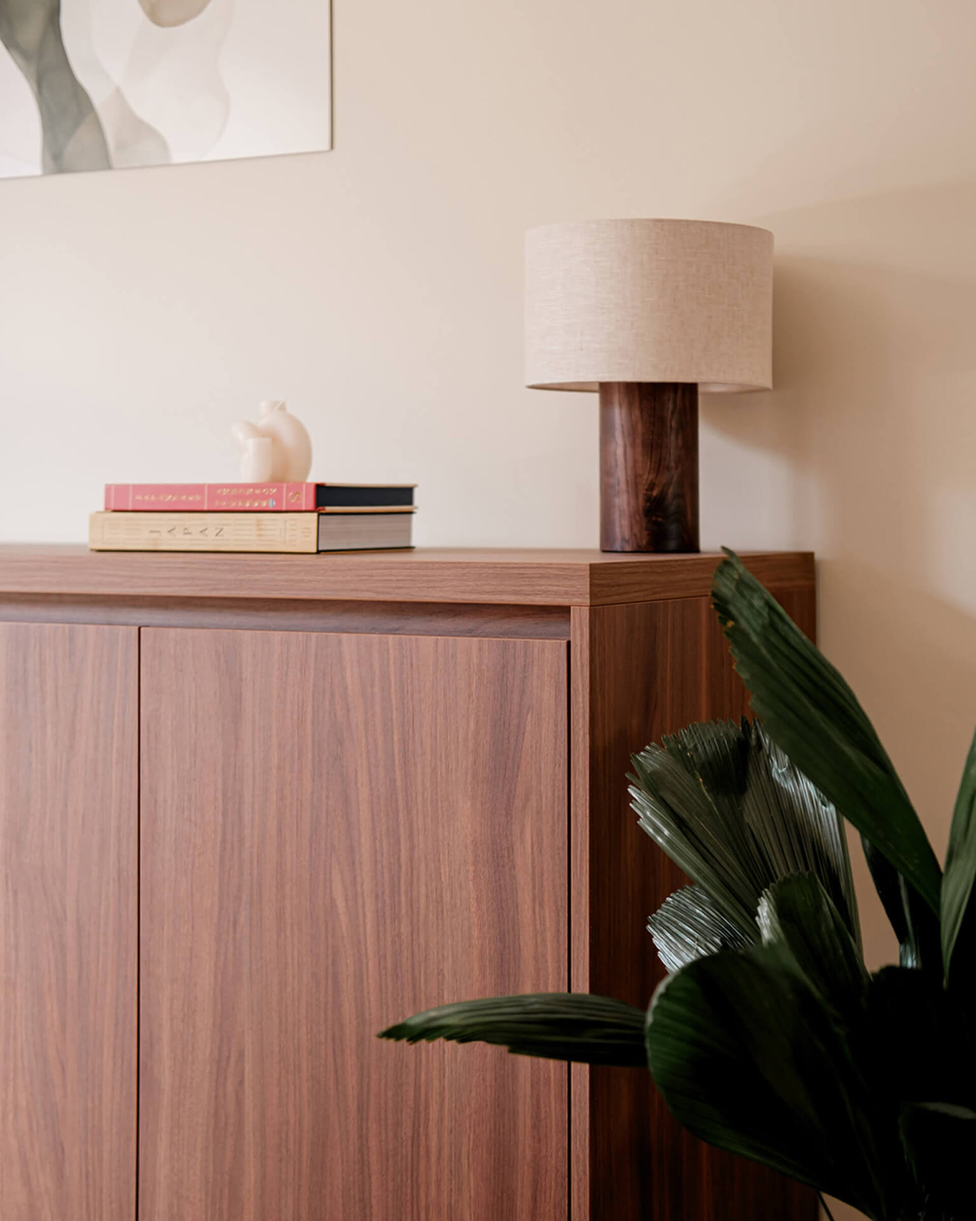 Commode couleur noyer décorée avec des livres et une lampe