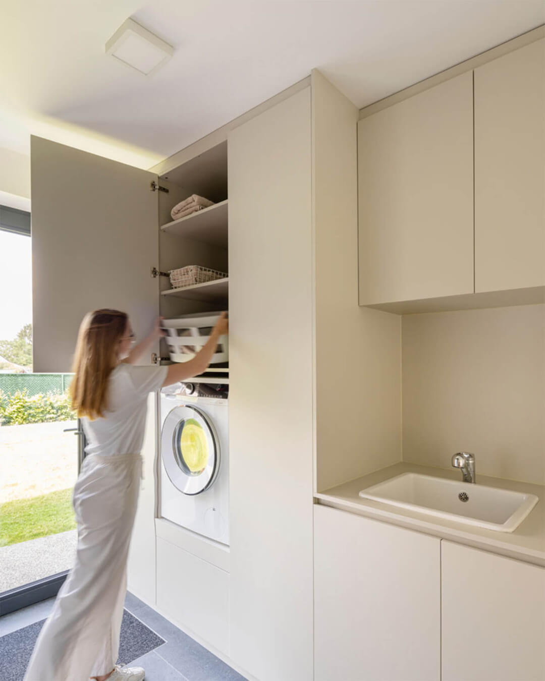 Combinaison murale d'armoires hautes et basses sur mesure avec espace pour une machine à laver intégrée en couleur gris chaud Turtle Grey