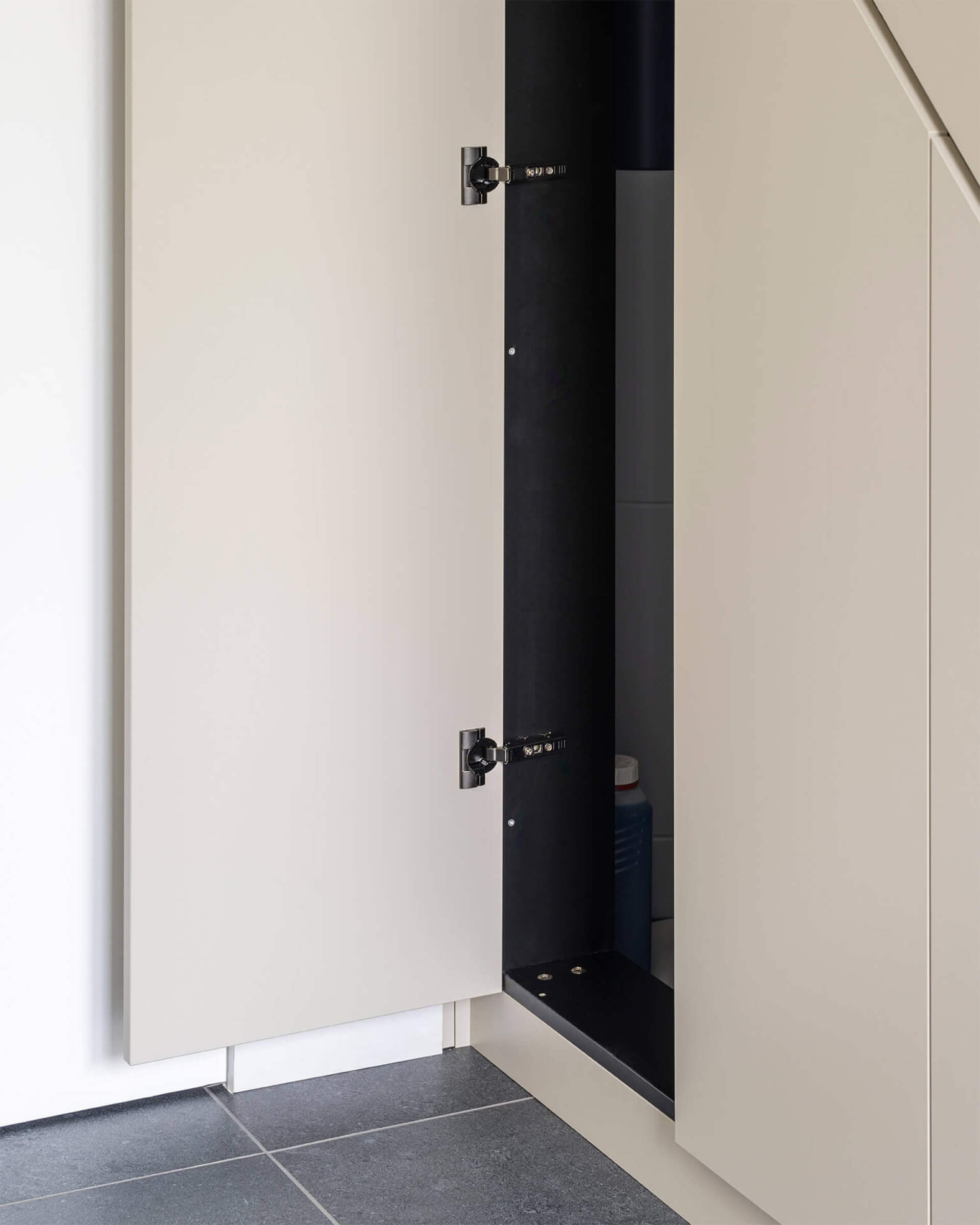 Gros plan d'une armoire sur mesure ouverte sous l'escalier