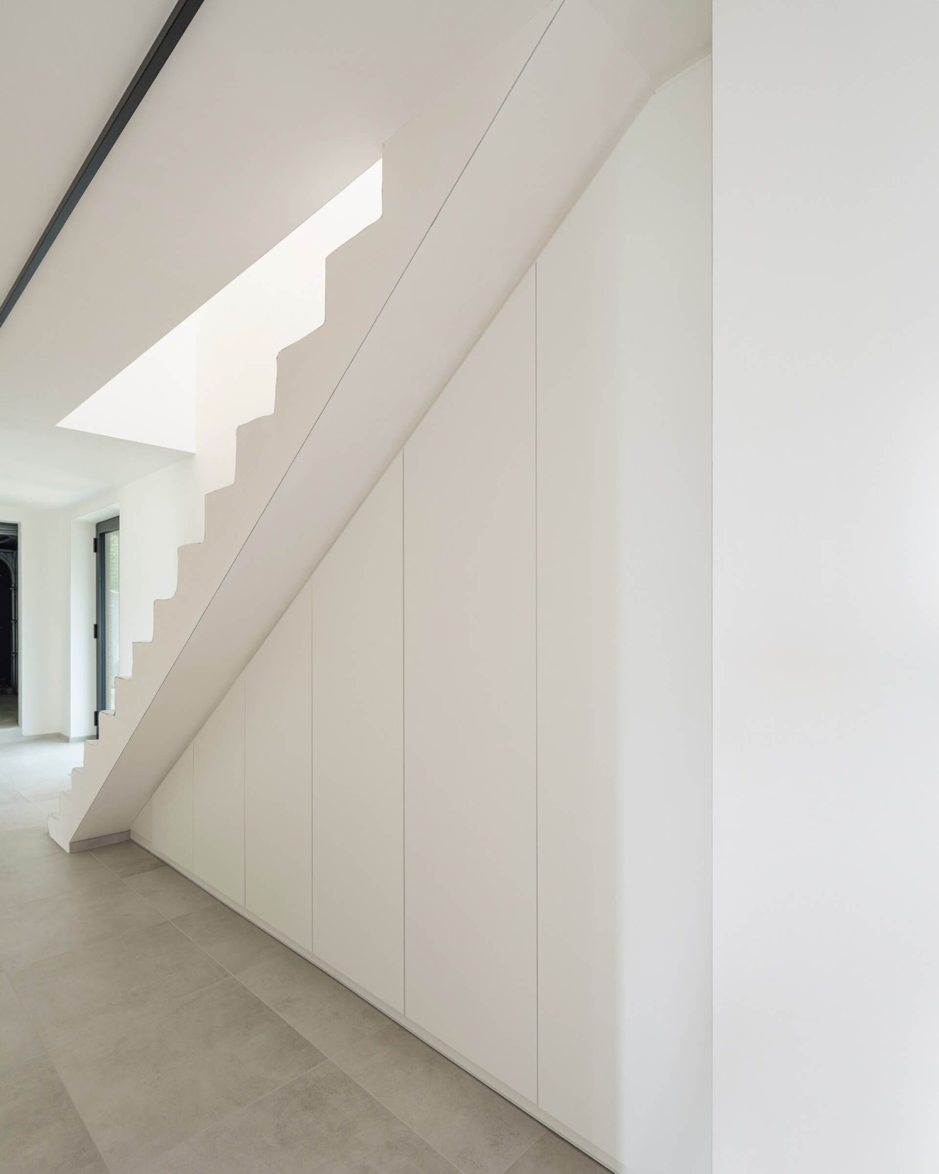 Hall avec une armoire sous escalier sur mesure en couleur Front white