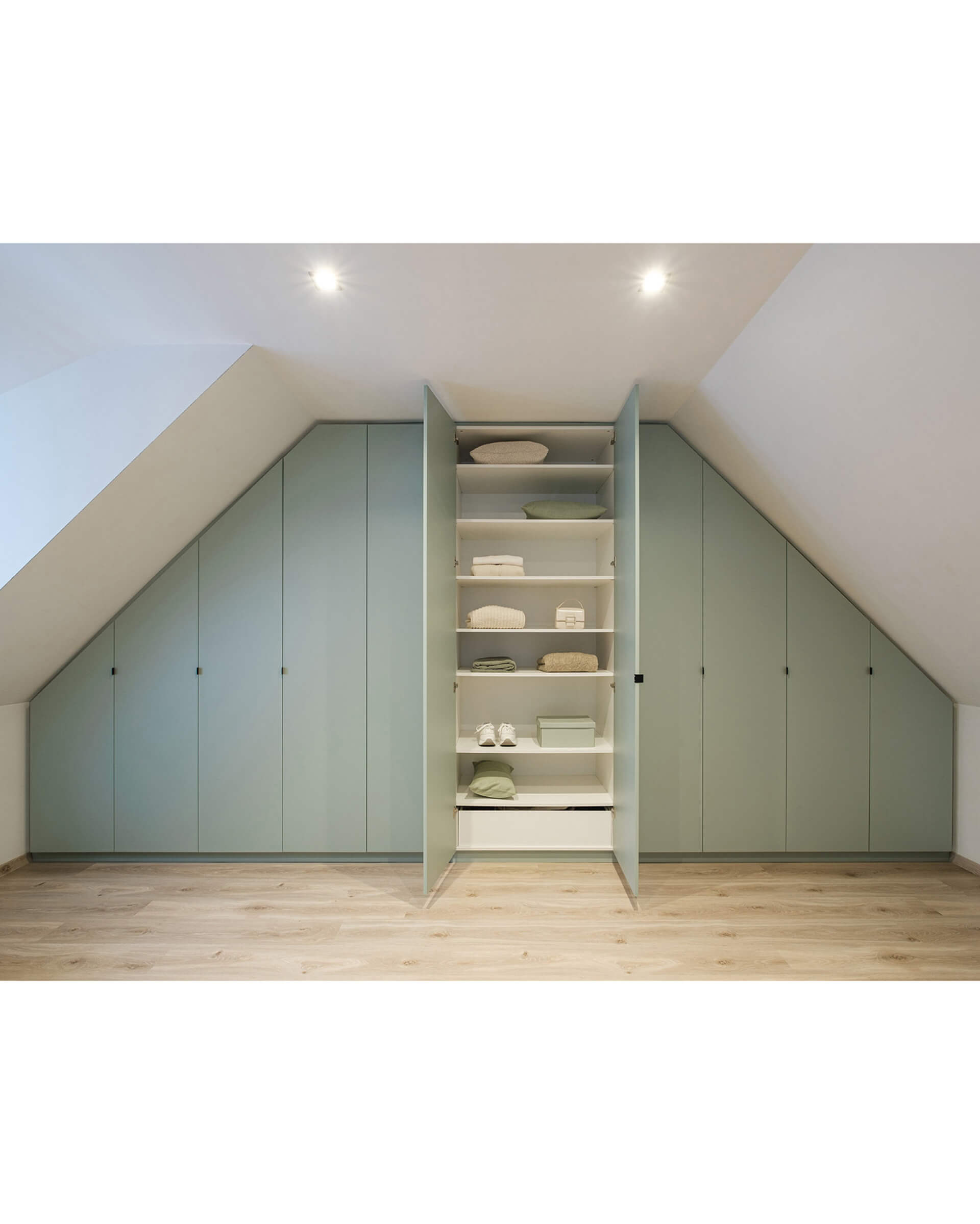 Armoire encastrée sur mesure sous un toit en pente de couleur Industrial Green
