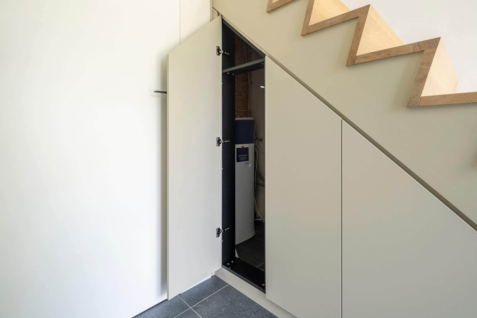 Éléments techniques dissimulés dans une armoire sous escalier sur mesure