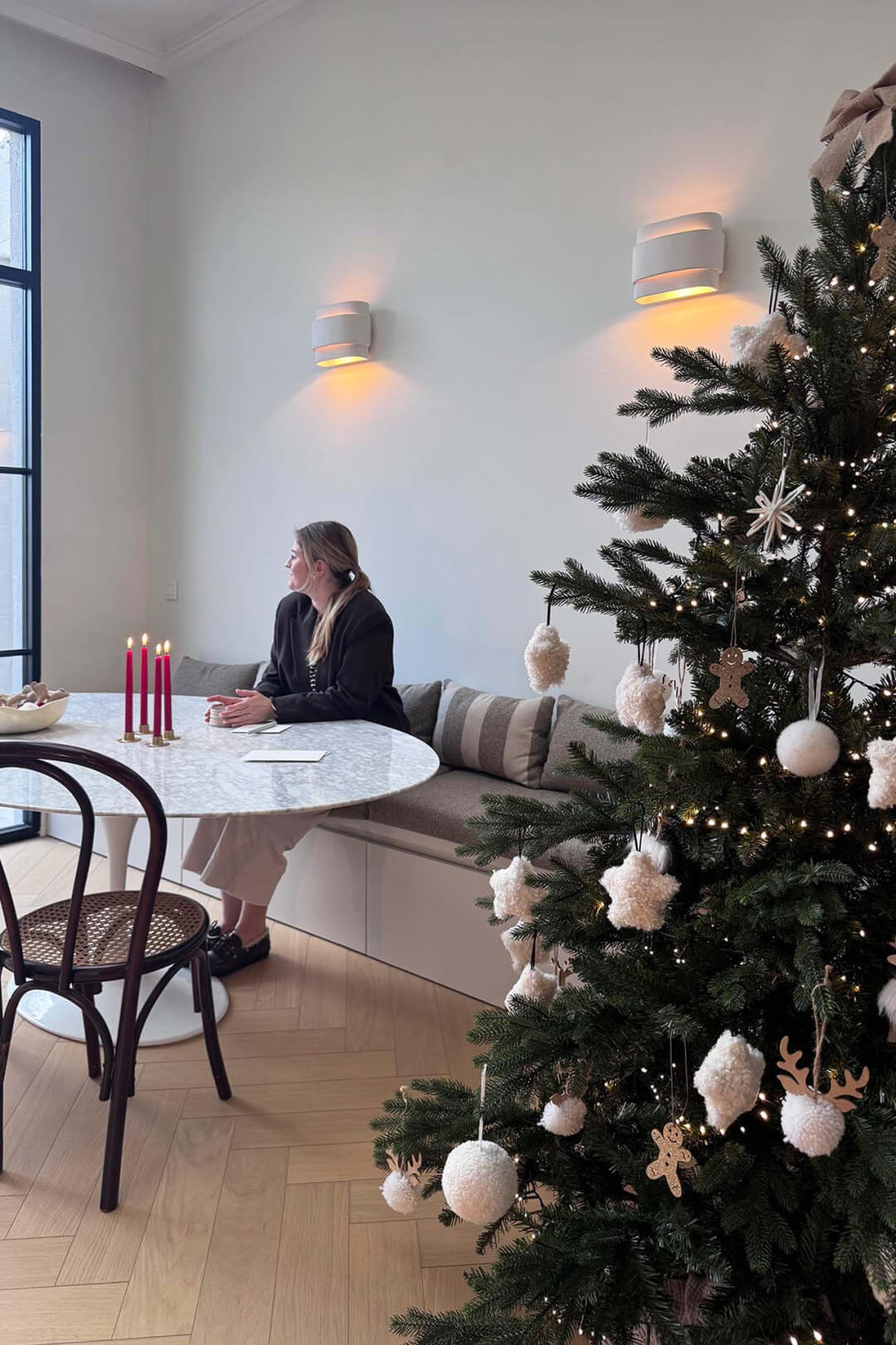 Personne assise sur un banc en forme de coquillage avec une rampe dans une salle à manger décorée pour Noël