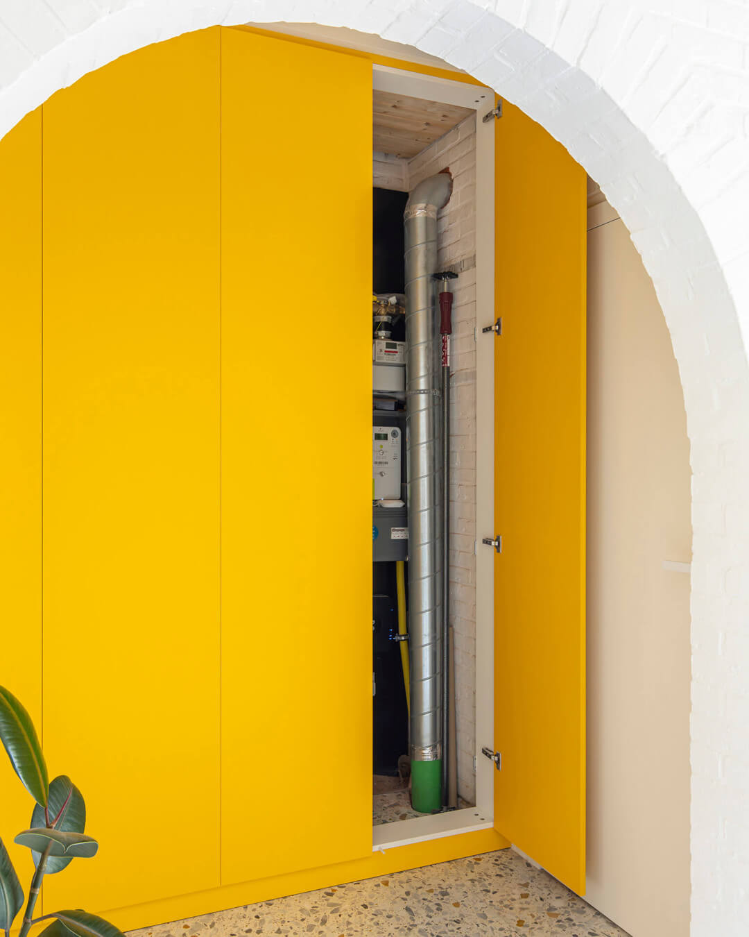 les tuyaux et le coffret de comptage sont dissimulés dans une armoire technologique jaune fabriquée sur mesure