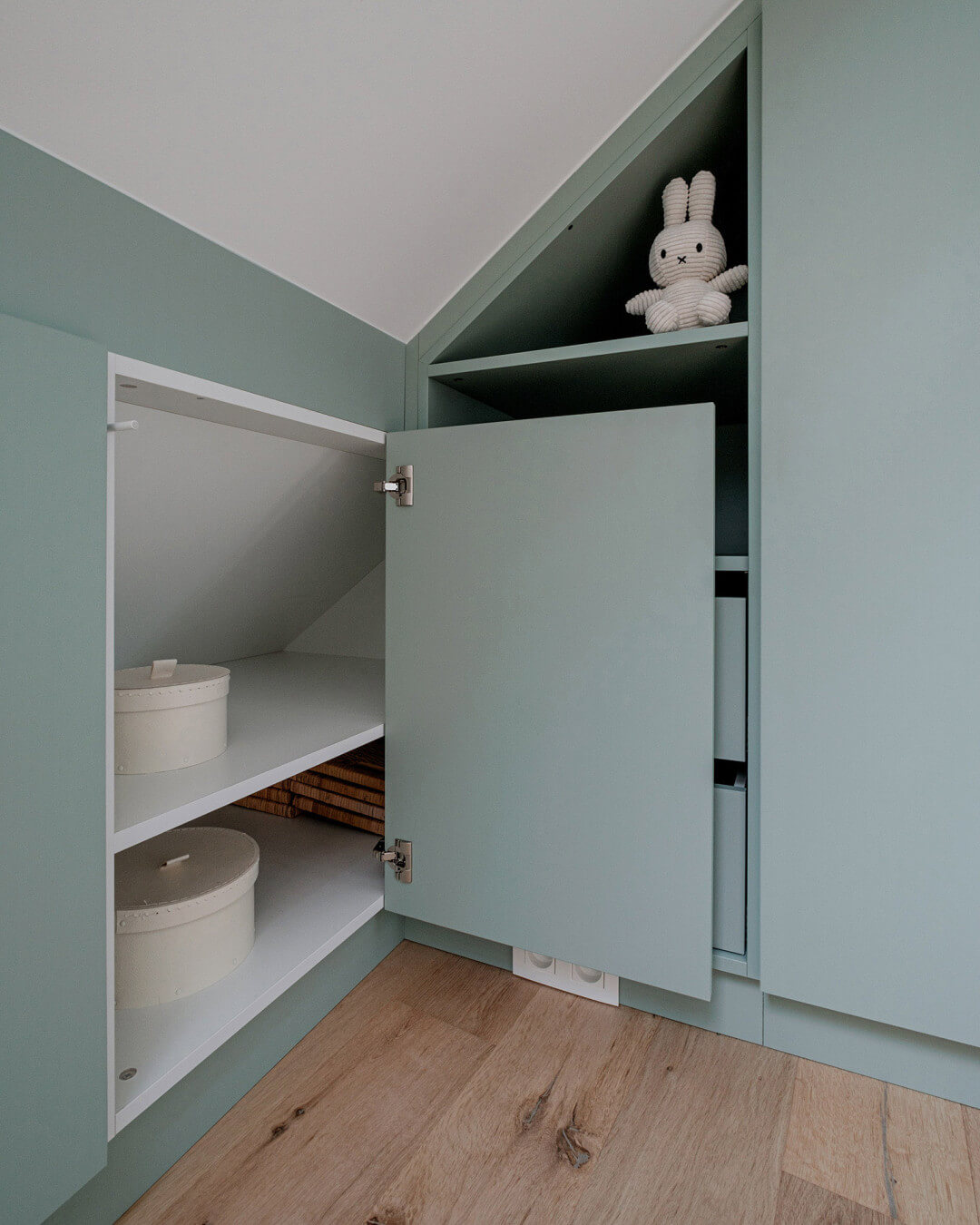 Armoire sur mesure sous un toit en pente dans la chambre des enfants, en Industrial Green