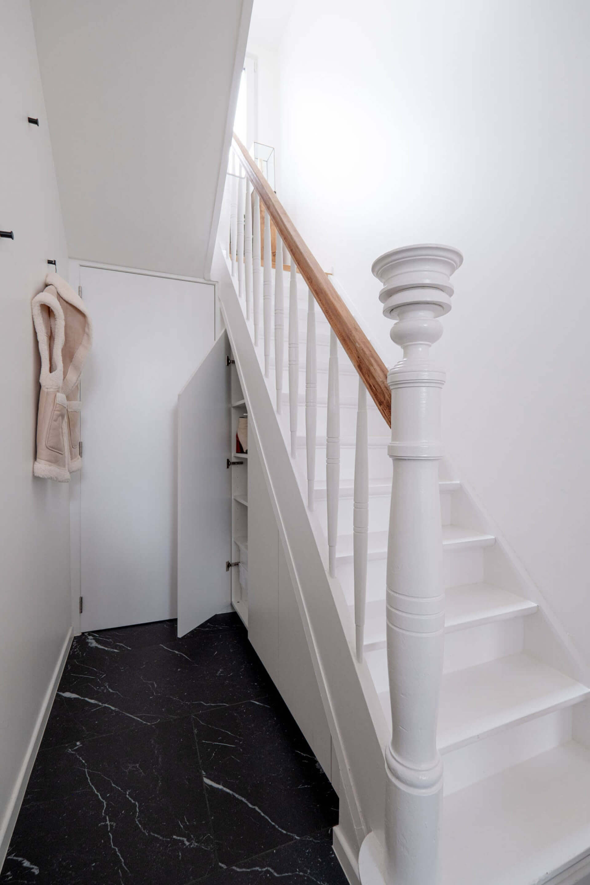 Hall avec une armoire ouverte sous escalier sur mesure blanche