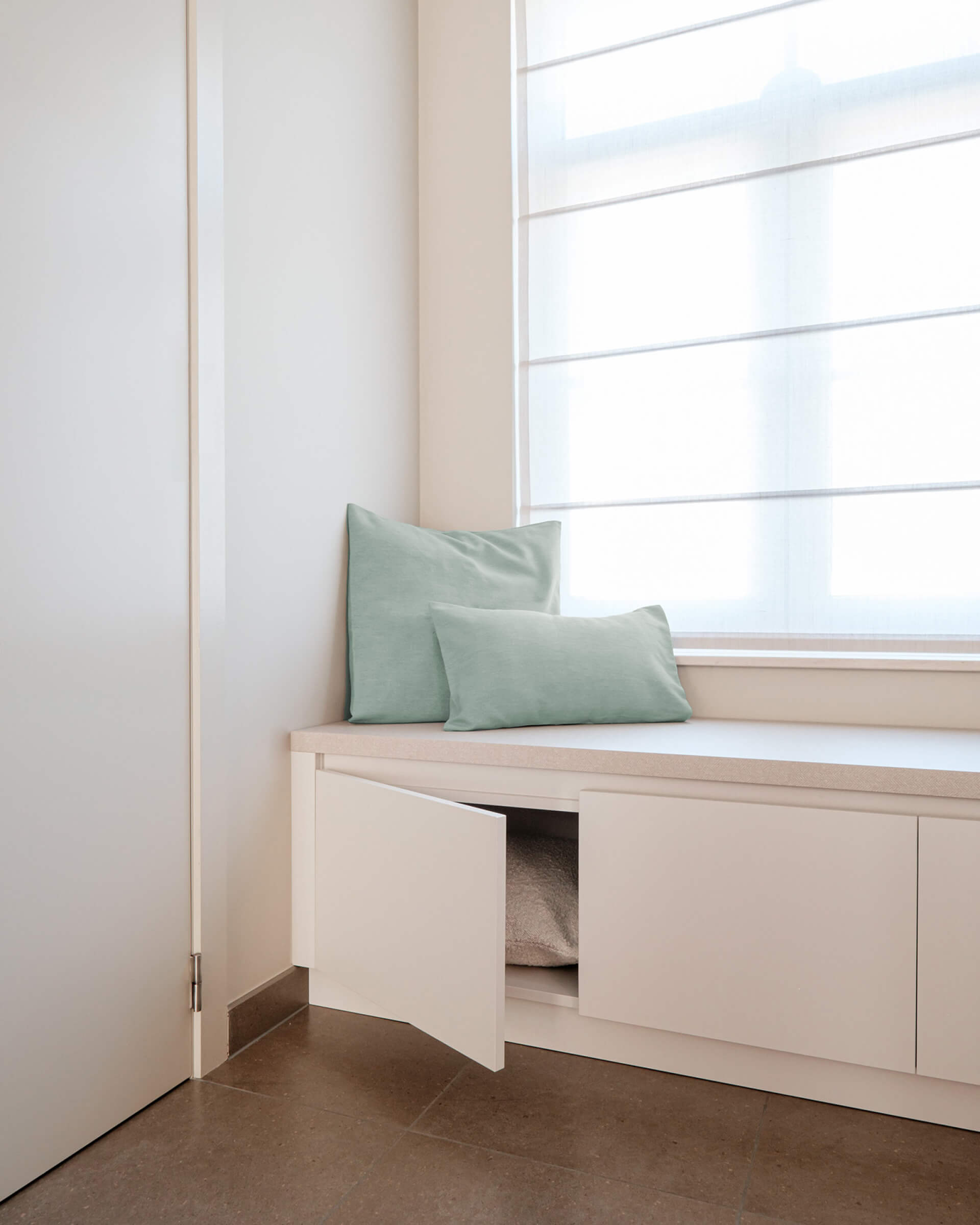 Banc de rangement blanc sur mesure avec listels en saillie.