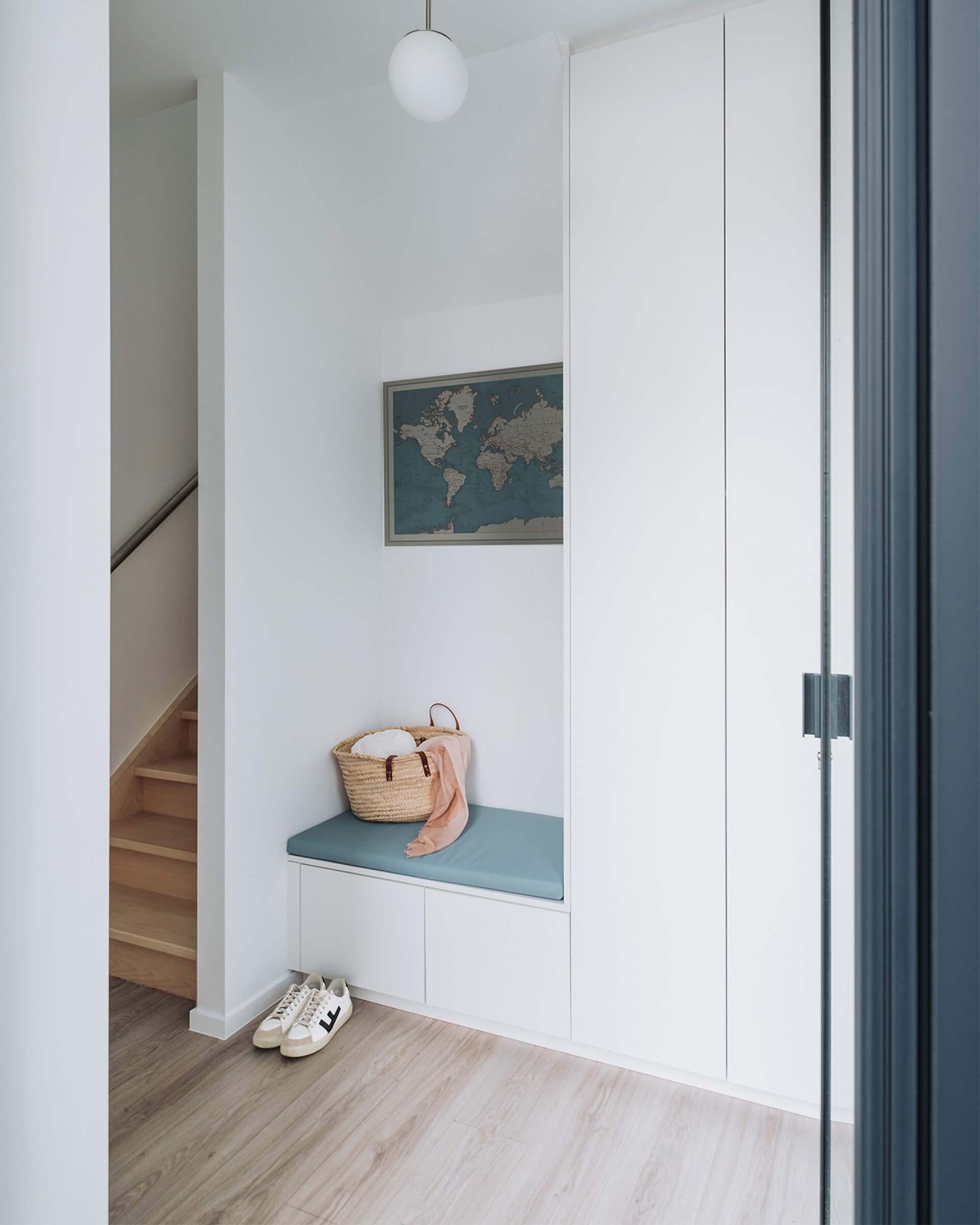 Banc de rangement blanc sur mesure avec portes à ouverture push-to-open.