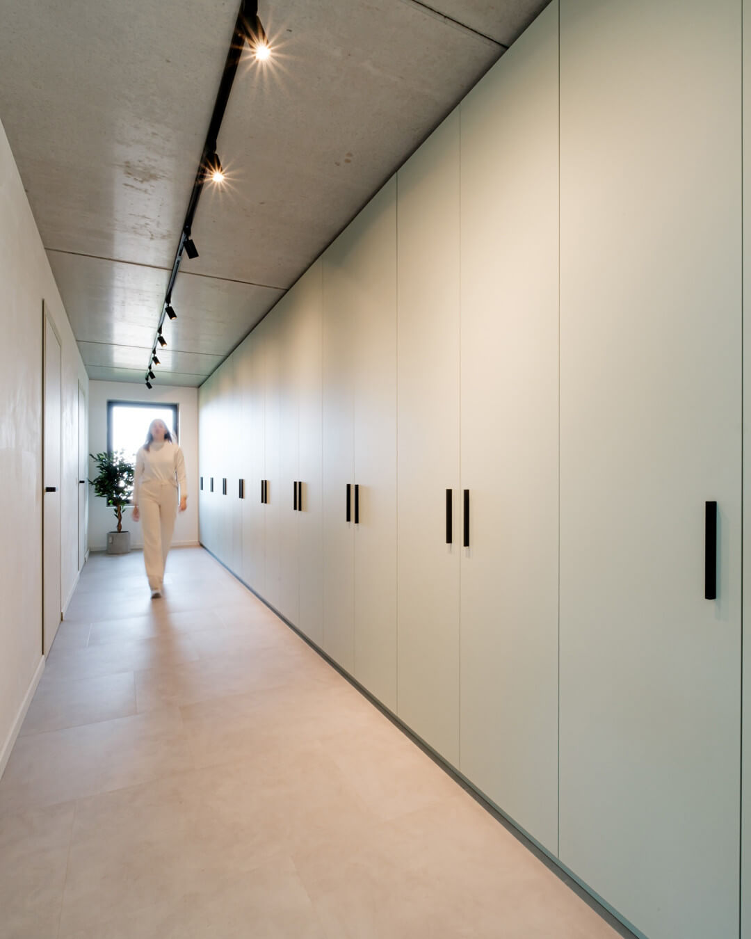 Grande armoire de rangement verte sur mesure en combinaison avec un sol en béton dans une maison moderne