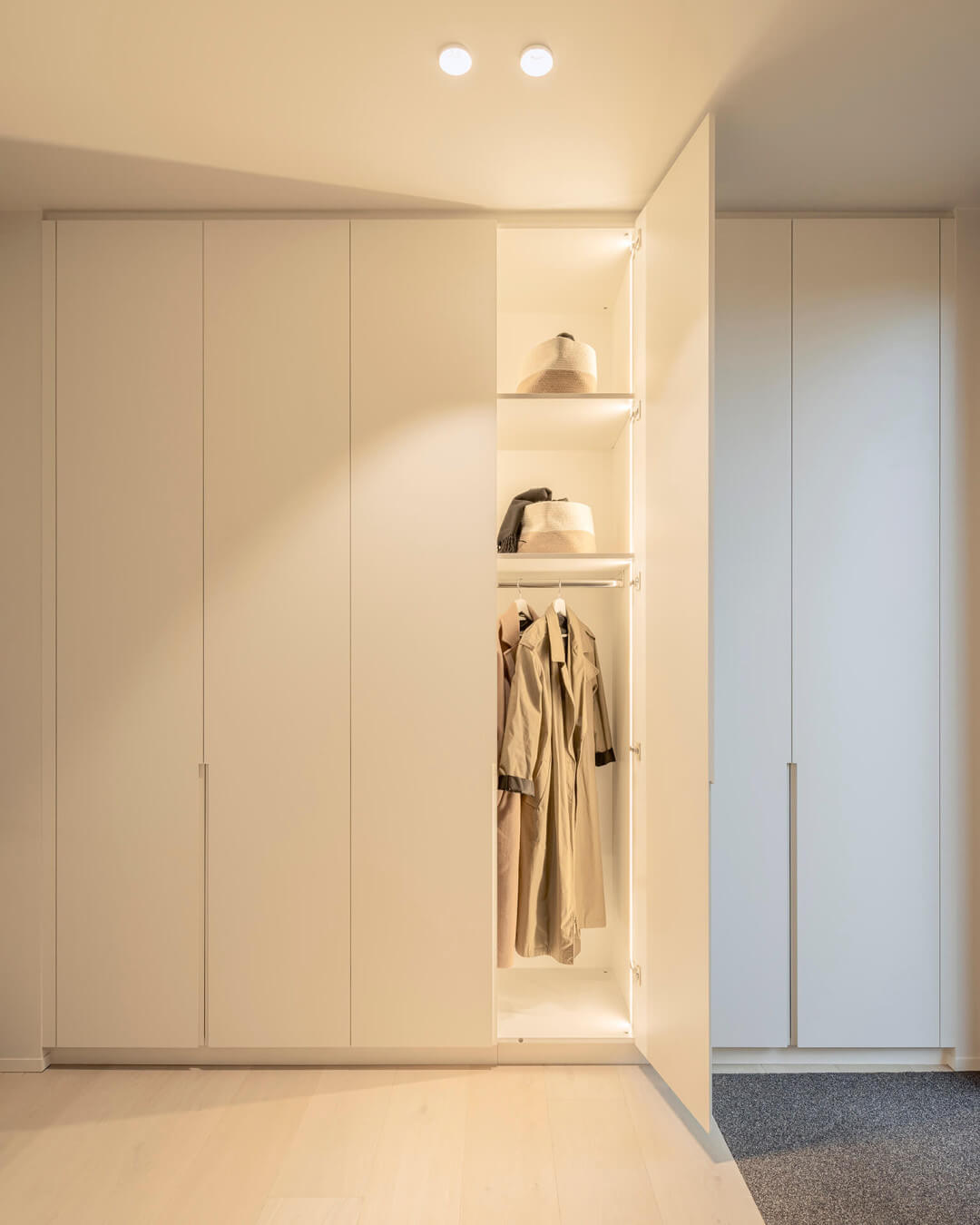 Vestiaire spacieux avec placard sur mesure dans un style neutre