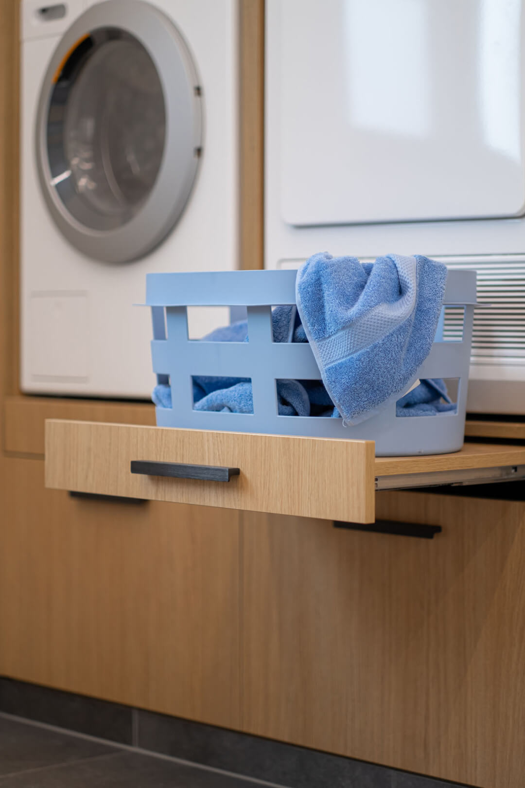 Plan de travail coulissant sous le lave-linge en chêne naturel Essential : un détail astucieux pour un meuble sur mesure