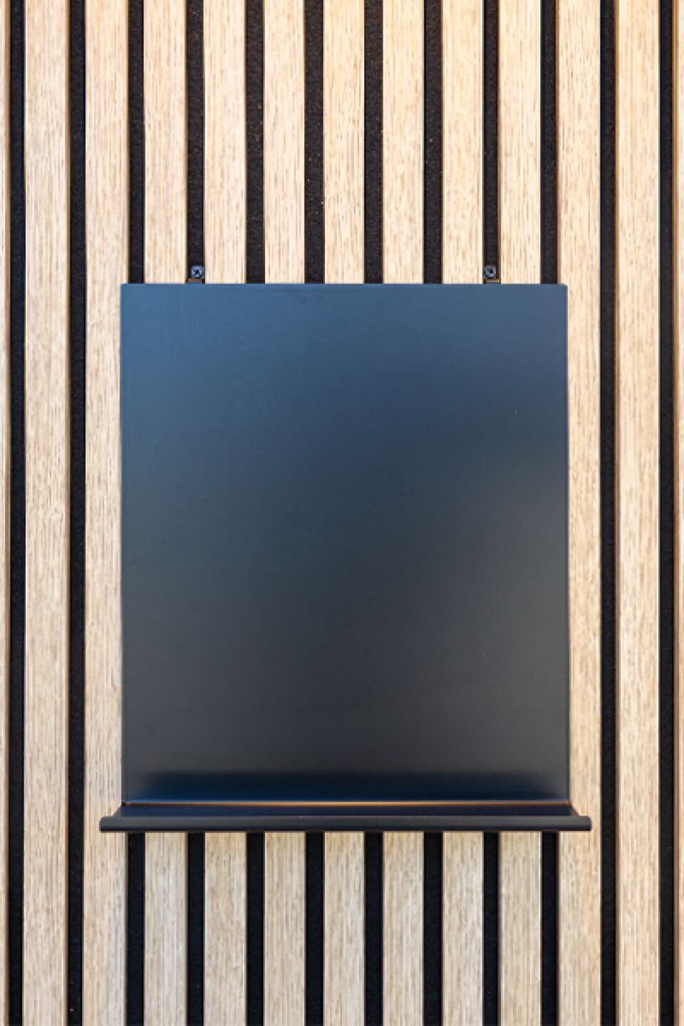 Vue de face d'un tableau magnétique avec une petite étagère sur un panneau mural acoustique. Disponible dans la boutique en ligne de Custoro.
