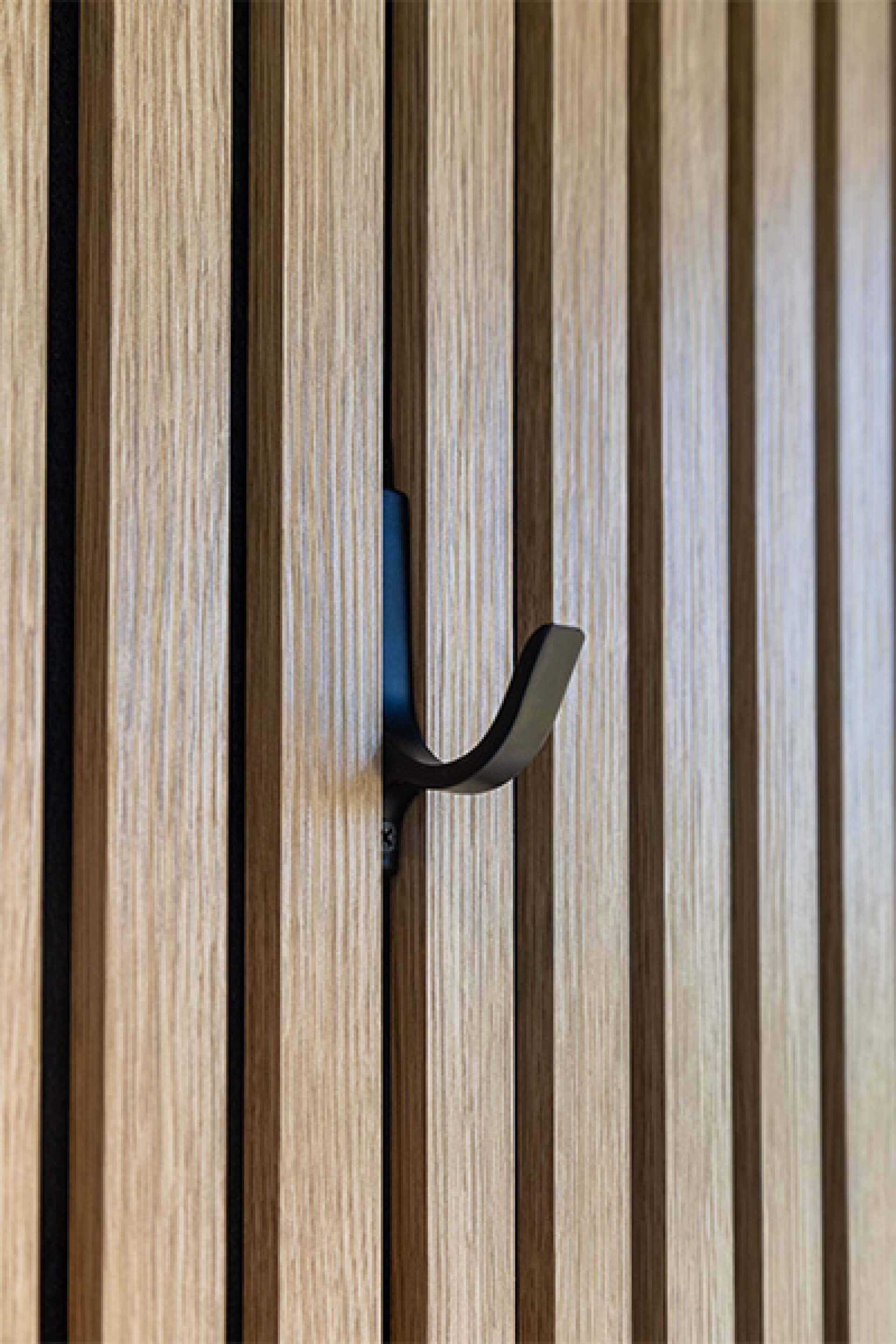 Vue latérale d'un crochet minimaliste sur un panneau mural acoustique. Disponible dans la boutique en ligne de Custoro.
