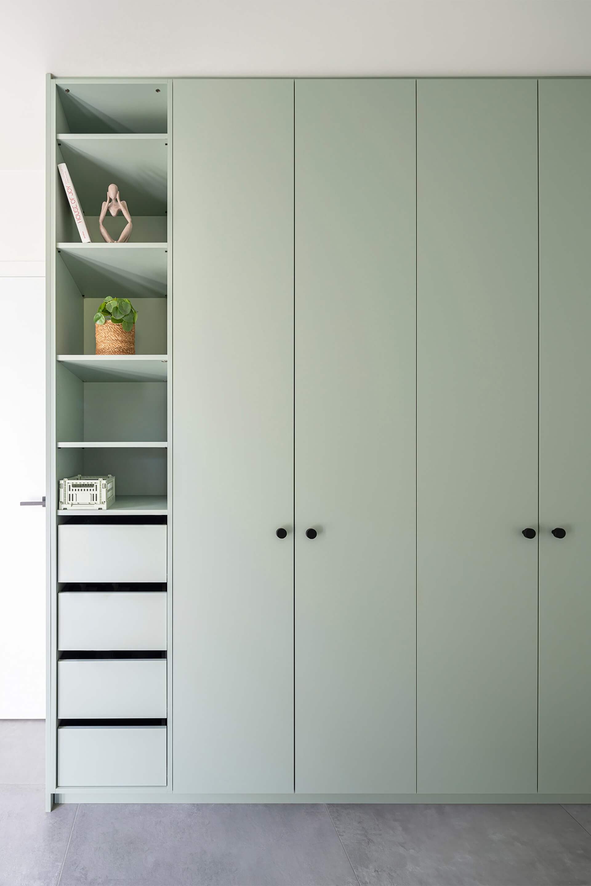 Armoire de rangement sur mesure, de couleur vert industriel, avec poignées Button noires.