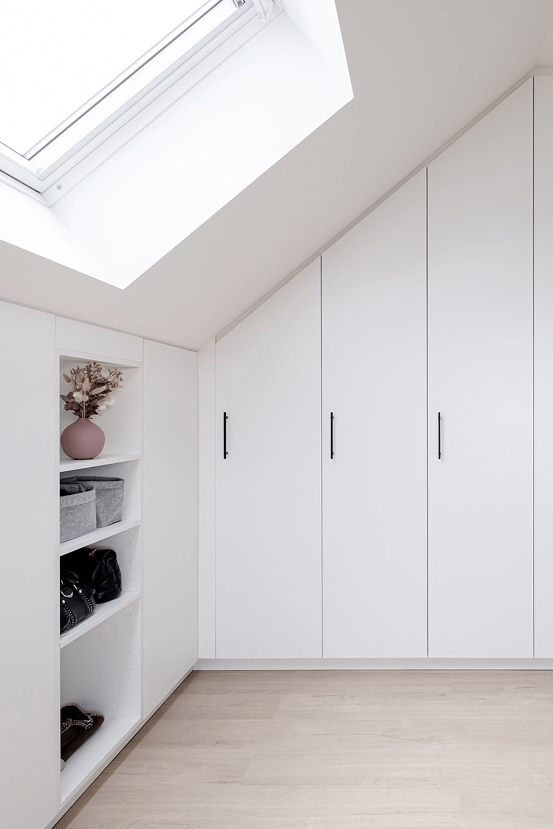 Poignées Black Diamond sur une armoire de grenier blanche sur mesure. Armoire murale inclinée sur mesure.