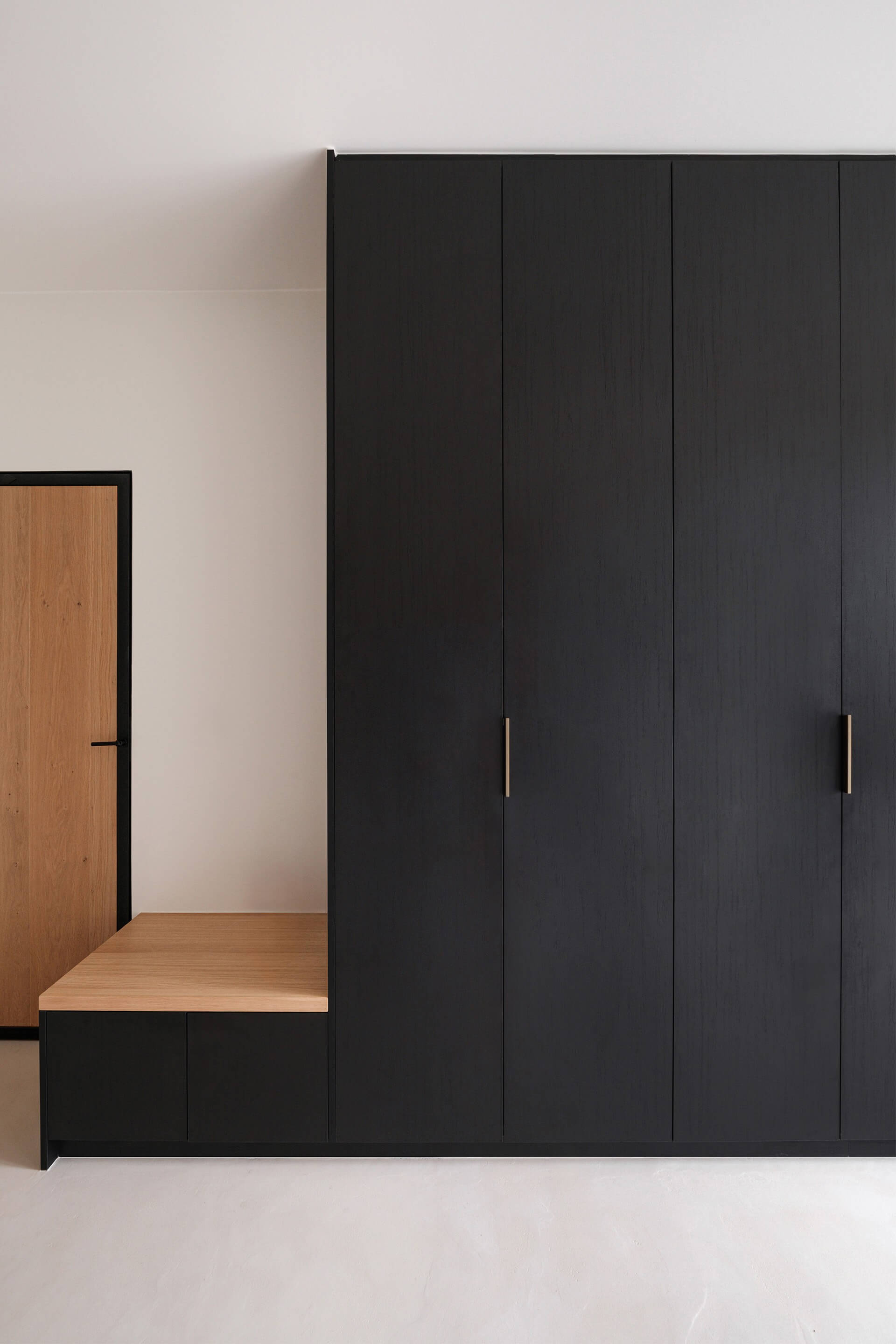 Poignées Pure en laiton sur un meuble de couloir sur mesure avec banc intégré, finition Noir Élégant.