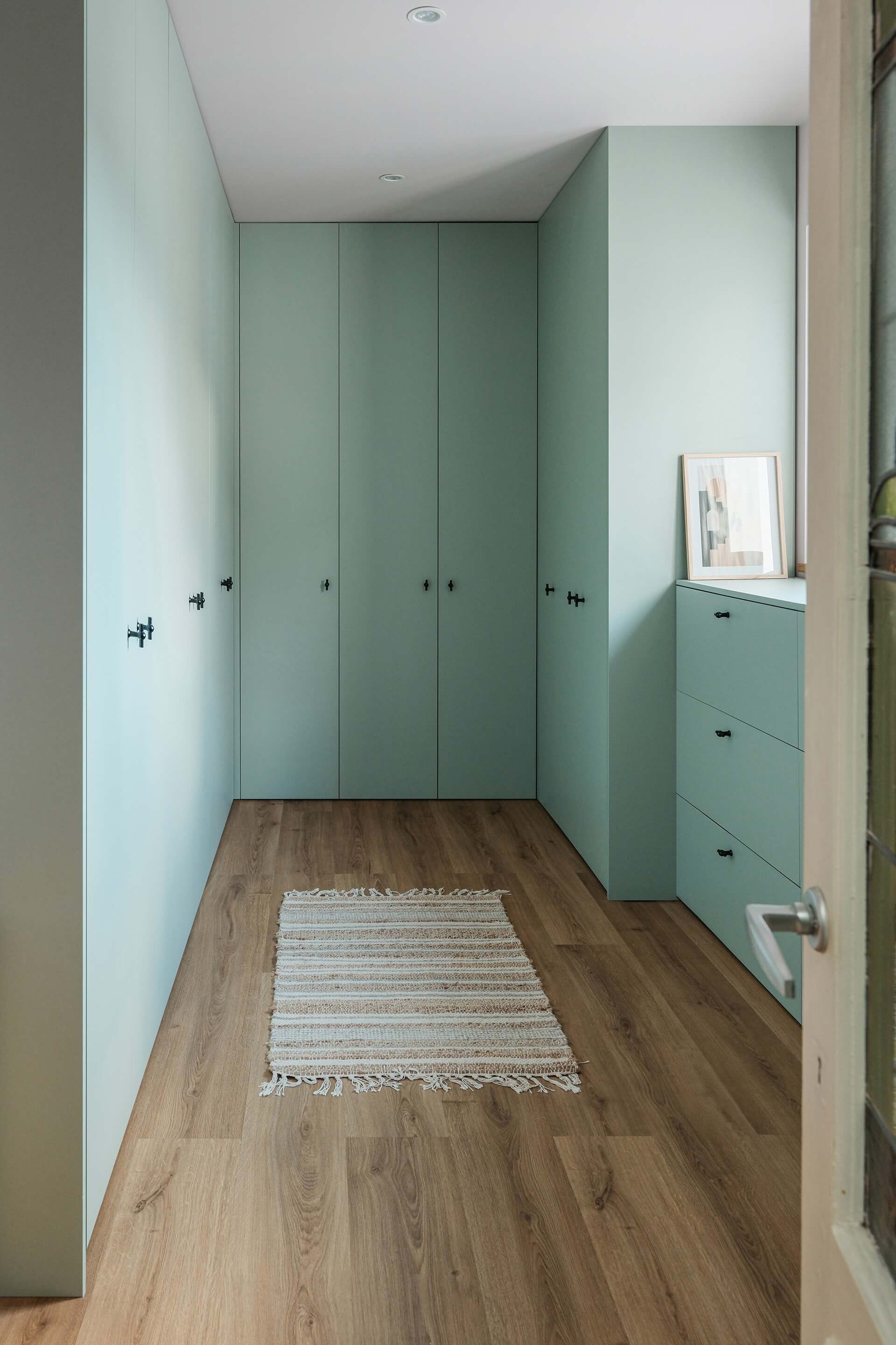 Meuble sur mesure en forme de U, de couleur vert industriel, avec poignées T-Classic noires.
